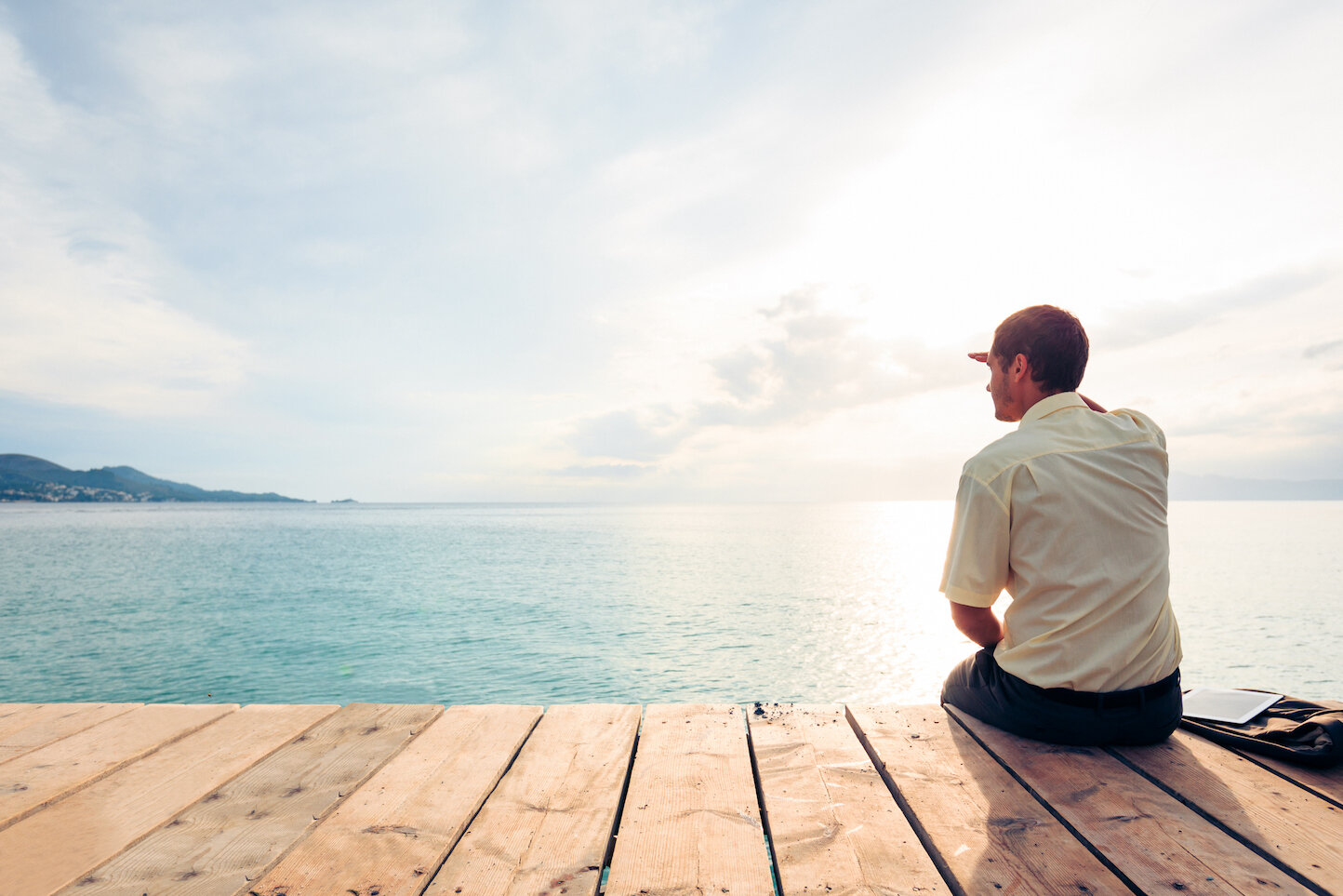 Business-man-sitting-on-pier-looks-out-over-water-188070320_2122x1415.jpeg