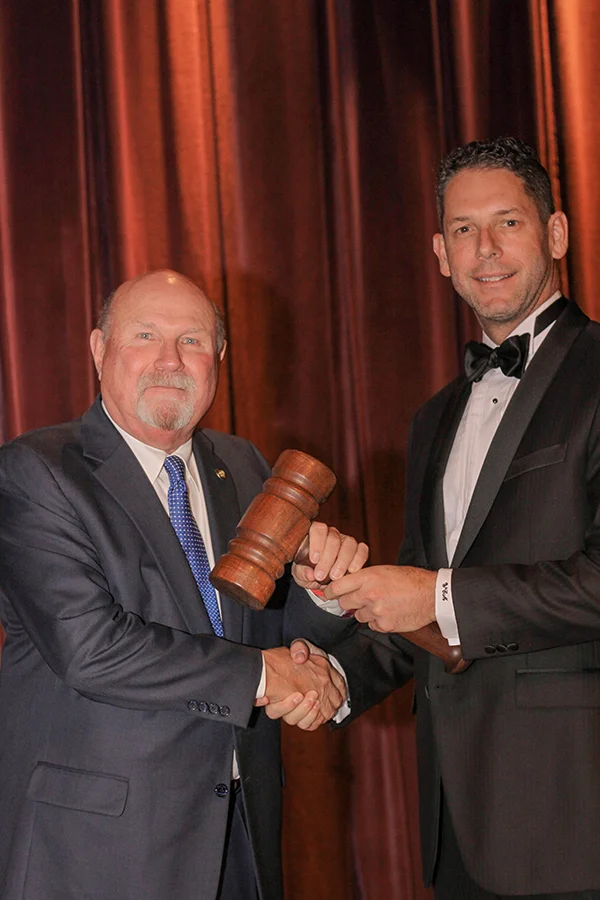 Fletcher Handley being passed the President’s gavel.