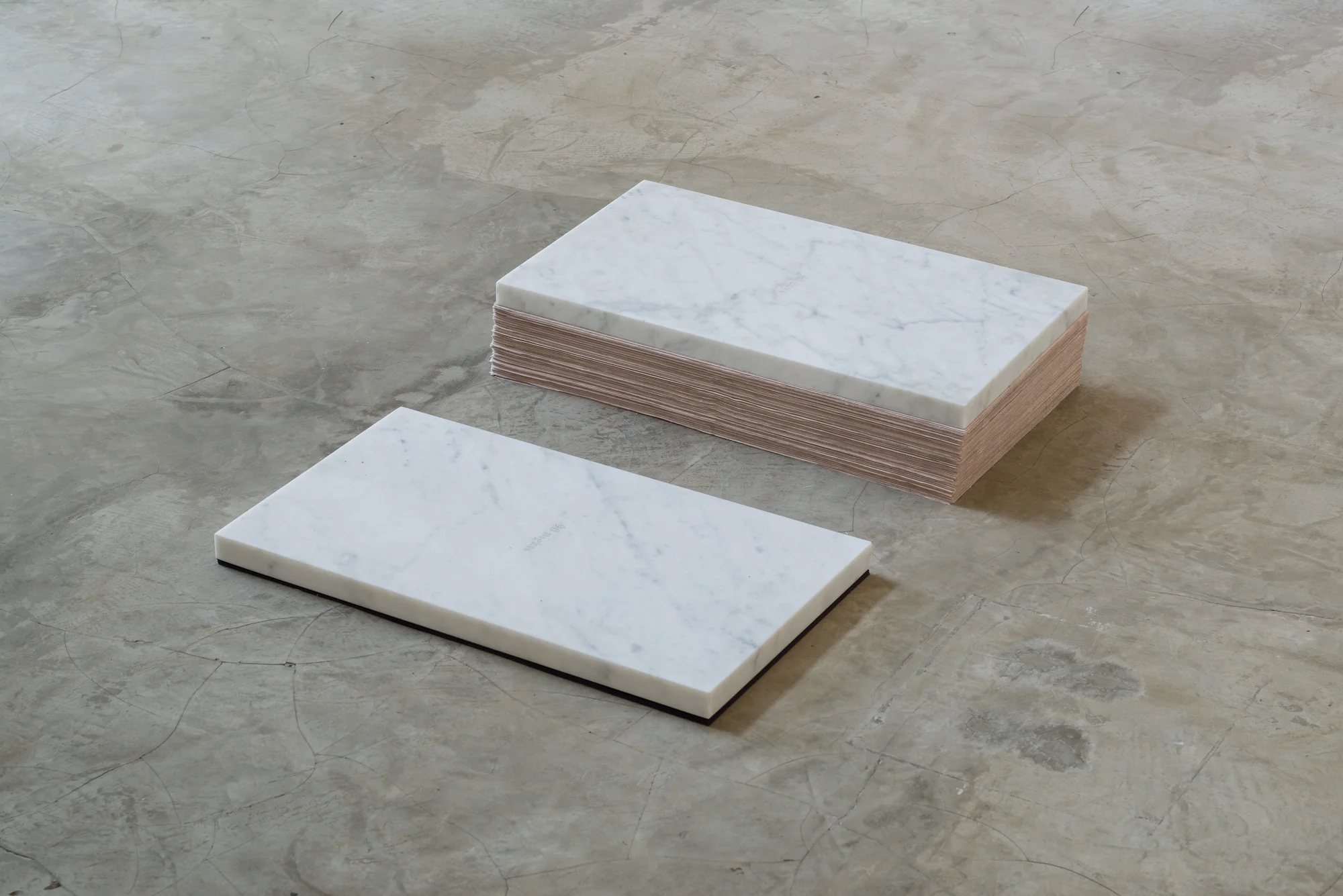 90 days, 90 nights 2016 Carrara marble, Lebanese newspaper Al Nahar, black sheets Dimensions variable On the left, 90 consecutive issues of Lebanese newspaper Al Nahar are piled up in reverse chronological order under a marble slab. The issue touching the ground marks the first day the artist started to think about this actual exhibition, the last newspaper, just below the slab, makes reference to the day when the show was installed, 90 days later. On the right, 90 thin black sheets are pilled under the 90 nights-marble slab.