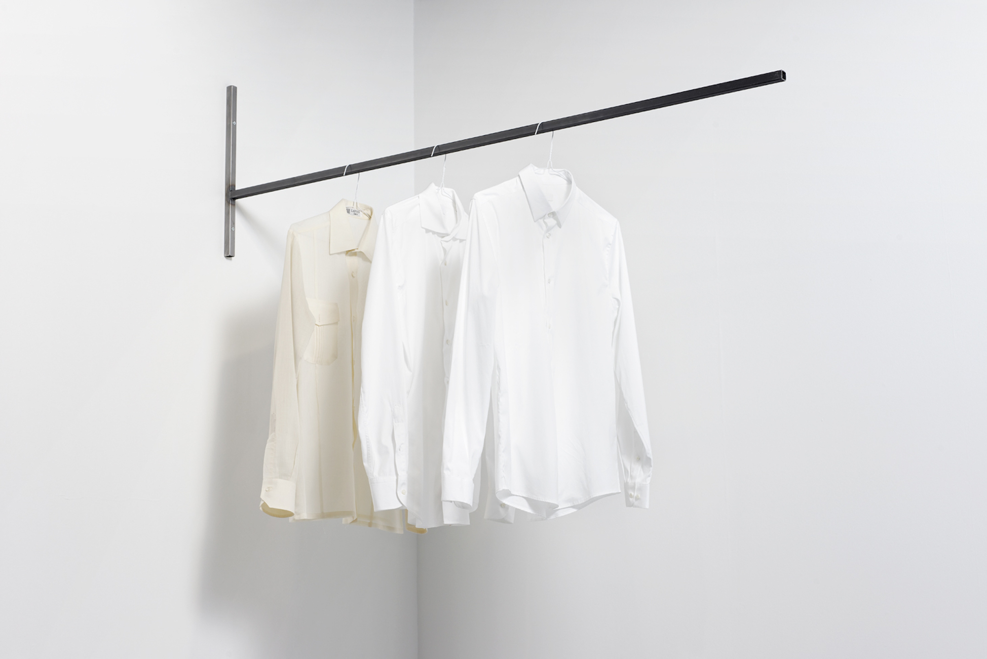  Three abstractions on three histories 2016 Three white shirts, metallic structure, time Dimensions variable   In 'Three abstractions on three histories' 3 shirts, apparently similar, hang high from the ground. They seem to belong to the same person,