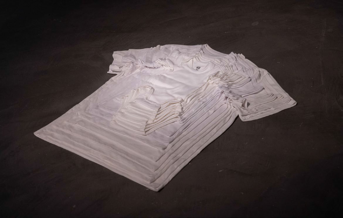  Pyramid, 2022, white bodies and t-shirts of all sizes (from 0-1 months to size XXL), thread, size of installation: 76 x 75 x 5 cm, edition 2/3  A pyramid is formed out of bodies and t-shirts of all available sizes sewn together, embodying the growth