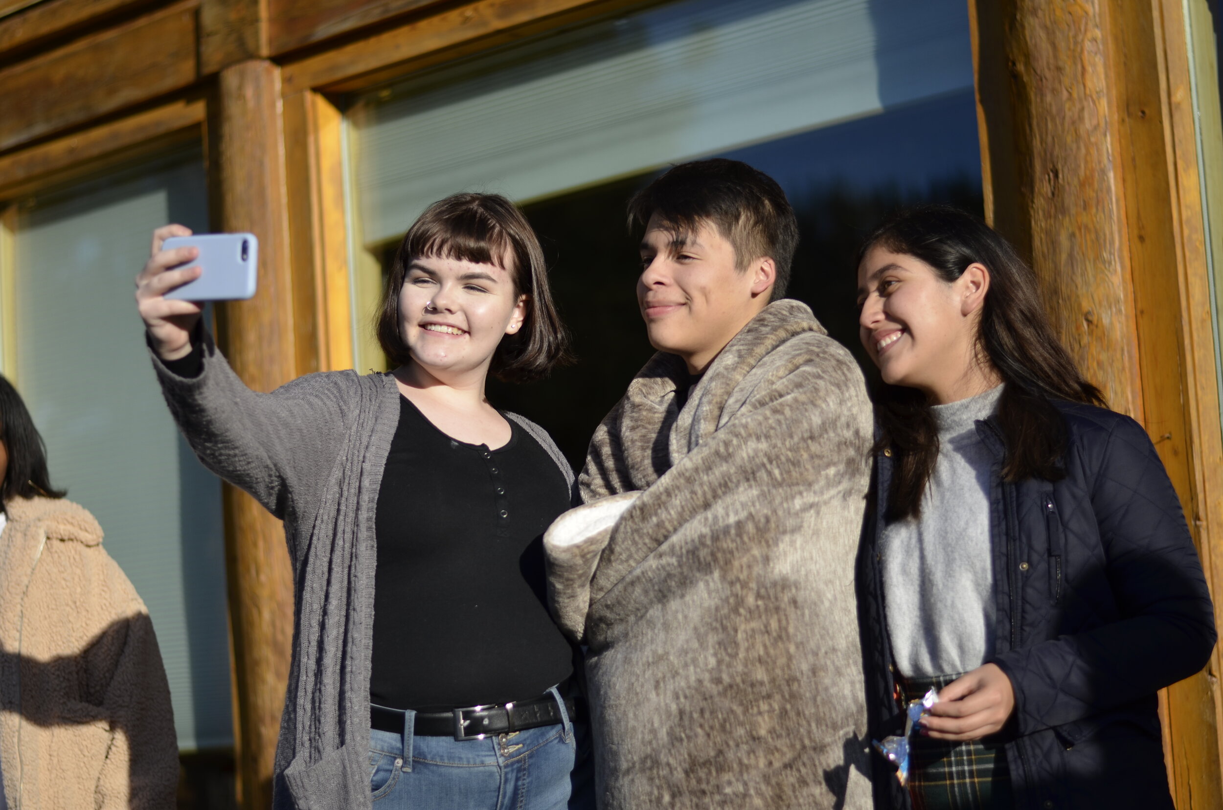  Ryleigh, Aaron, and Michelle from the Washington World Fellows program pose for a selfie in front of the cabin rented for the program’s college prep Writing Weekend. 