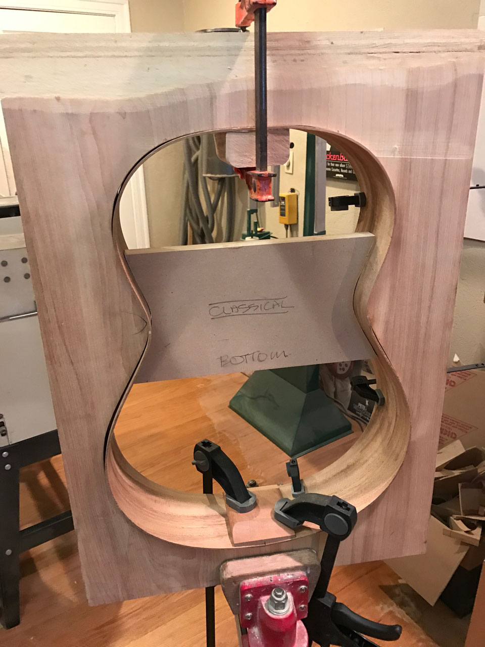 HERE, A CLASSICAL "HOOP", OR BODY SHELL, IS FITTED INTO ITS MOLD PRIOR TO GLUING IN THE LINING STRIPS. THE NECK HEEL AND TAIL BLOCKS HAVE BEEN GLUED AND ARE CLAMPED INTO PLACE UNTIL THE GLUE DRIES.
