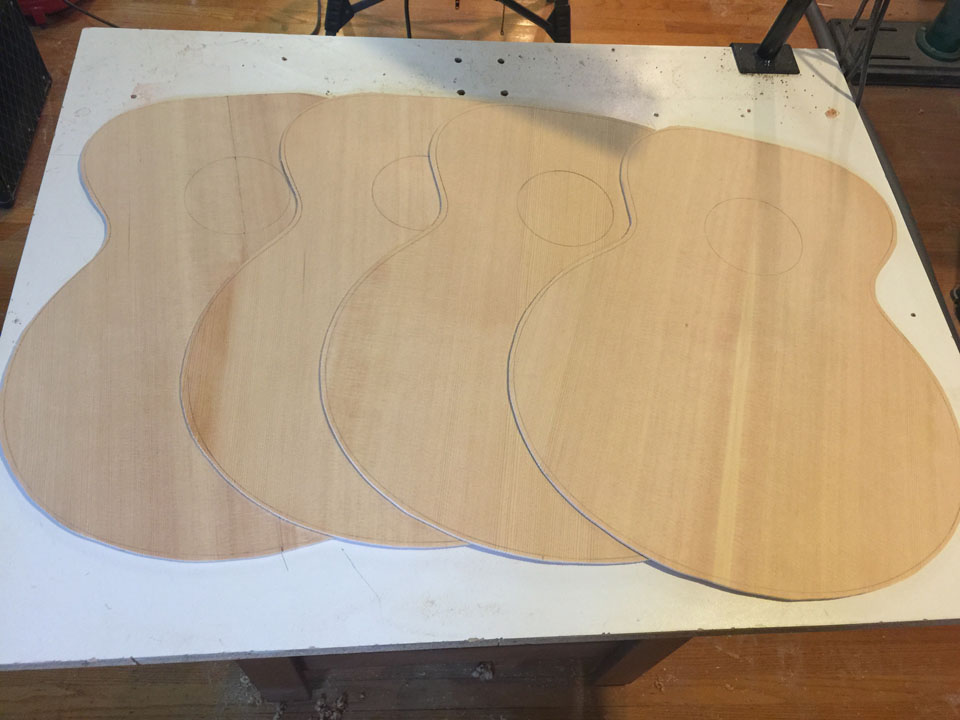 A GROUP OF 700C JUMBO TOPS ARE ROUGH-CUT FROM THE GLUED-UP TOP PANELS. TOPS ARE CUT 1/4" LARGER ALL AROUND.
