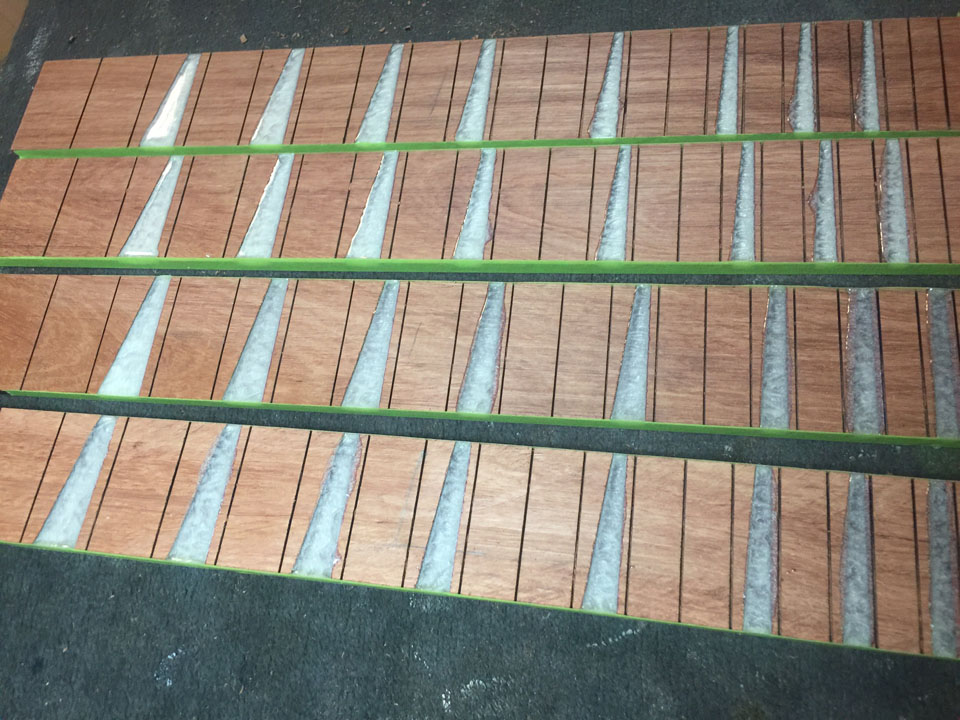 HOW THE FRETBOARDS LOOK ONCE THE FRET MARKERS ARE POURED USING PEARL LIQUID RESIN, THEN FLATTENED.