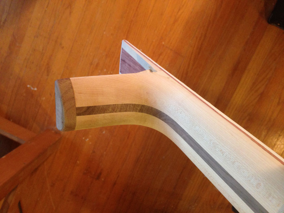A DECORATIVE, CONTRASTING HEEL CAP IS GLUED INTO PLACE ON THE BOTTOM OF THE NECK HEEL.