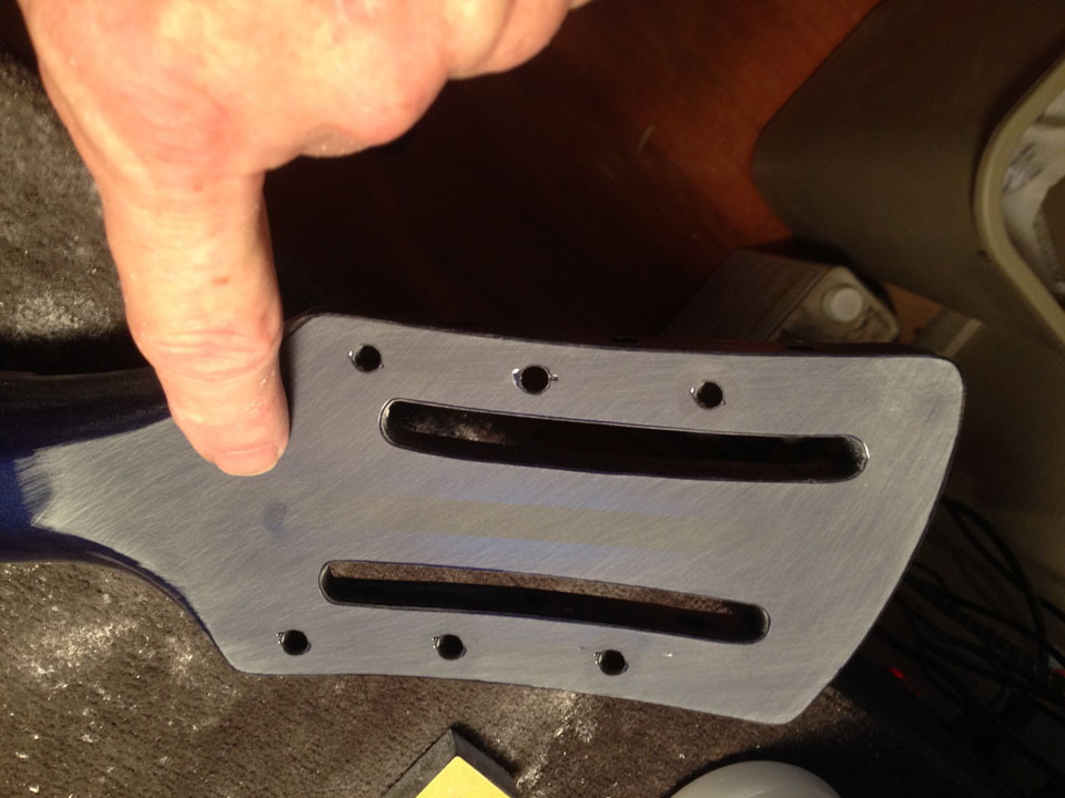 BACK OF HEADSTOCK IS NOW DEAD FLAT; FINGER POINTS OUT TINY FLAW THAT WILL BE CORRECTED BEFORE NEXT CLEAR COAT.