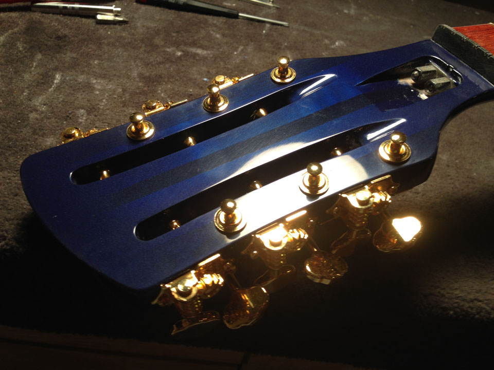 HEADSTOCK TAKING SHAPE WITH 12 GOLD TUNING MACHINES. "HALO" SCRATCHES IN CLEAR COAT FILL WITH WAX IN FINAL STEP.