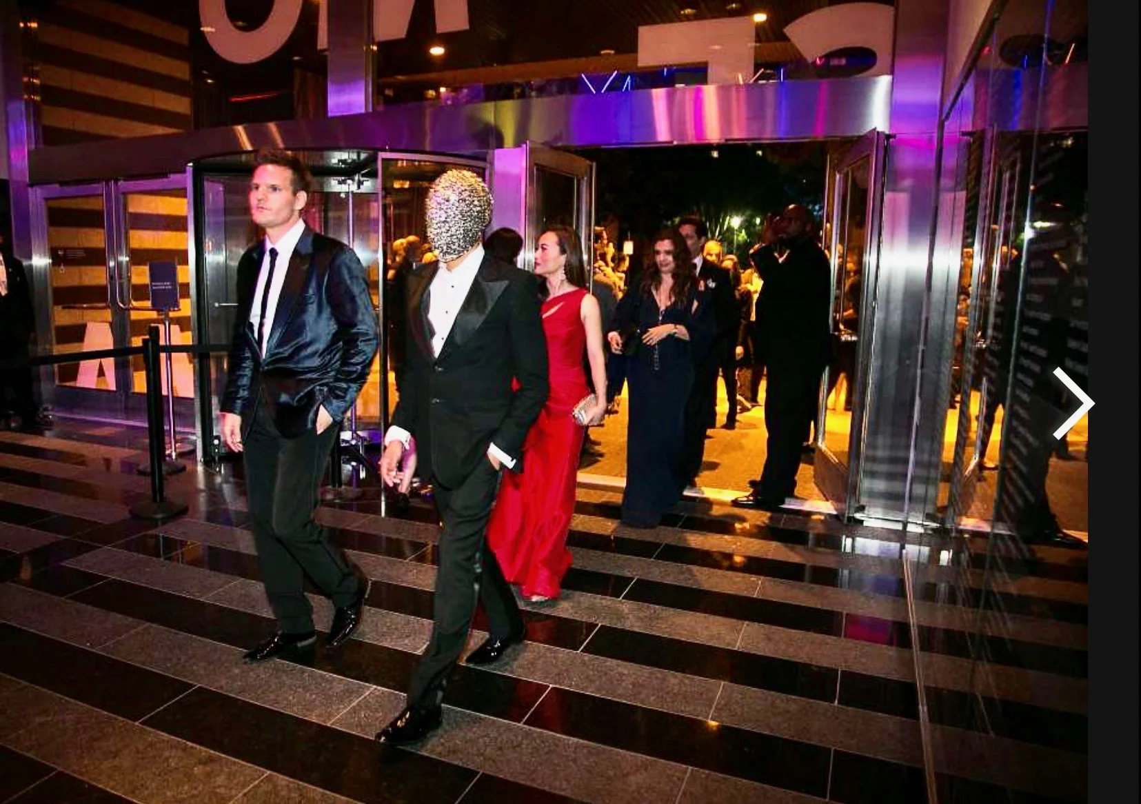 To make a splash for the reopening of SFMOMA, Gari donned actually, a Margiela bejeweled mask. It worked and he inserted Margiela for Archer as what he was wearing.... Check out the article https://www.sfgate.com/art/article/Artsy-Modern-Ball-the-pinnacle-of-SFMOMA-s-7466694.php#photo-10059955