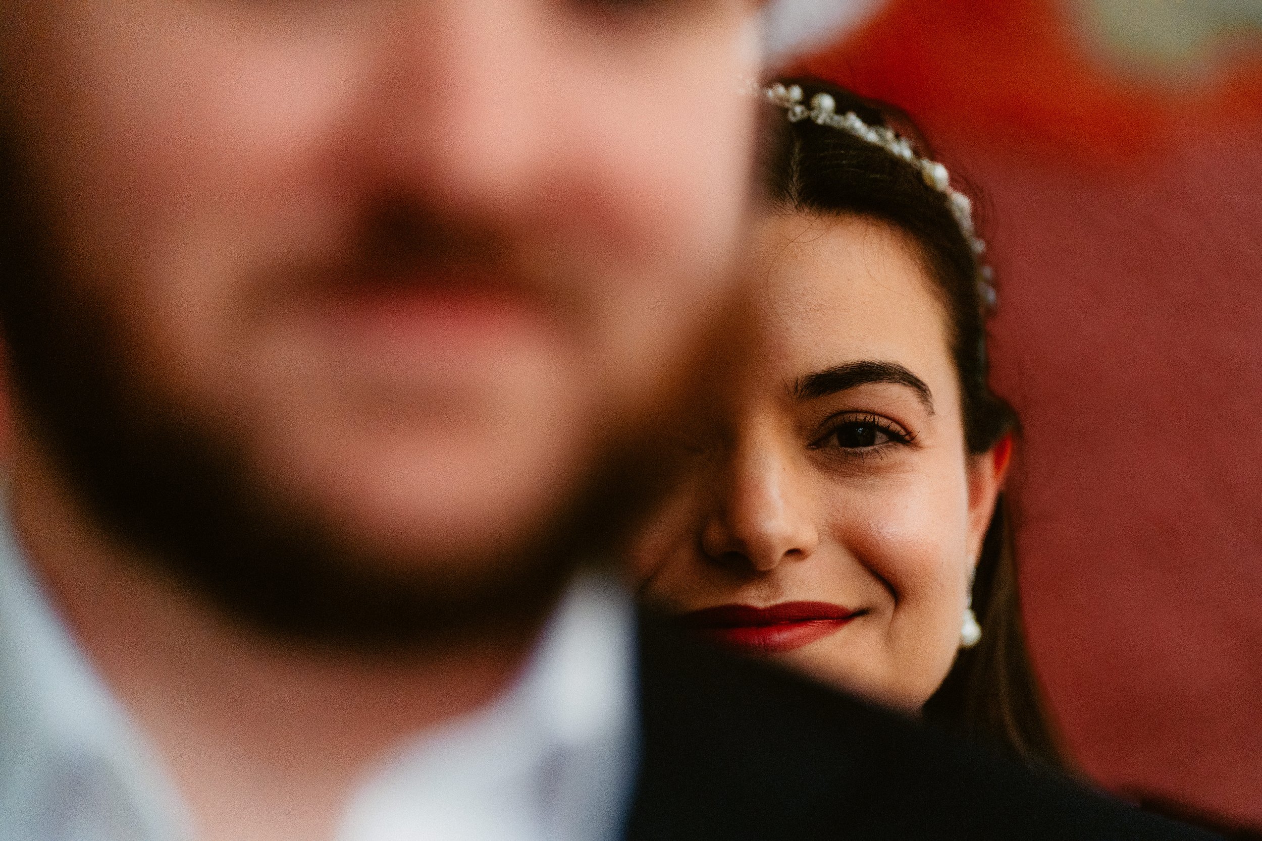 Honeymoon shoot in Edinburgh with a couple visiting from Florida, featuring a close portrait focusing on the bride’s face as she smiles behind the groom.