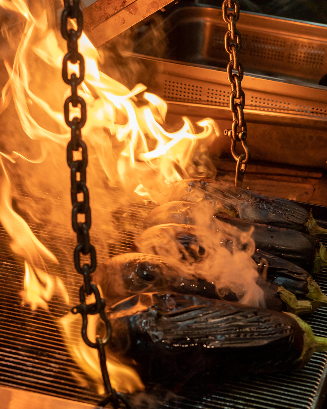  Flames burning Eggplants on a chargrill 