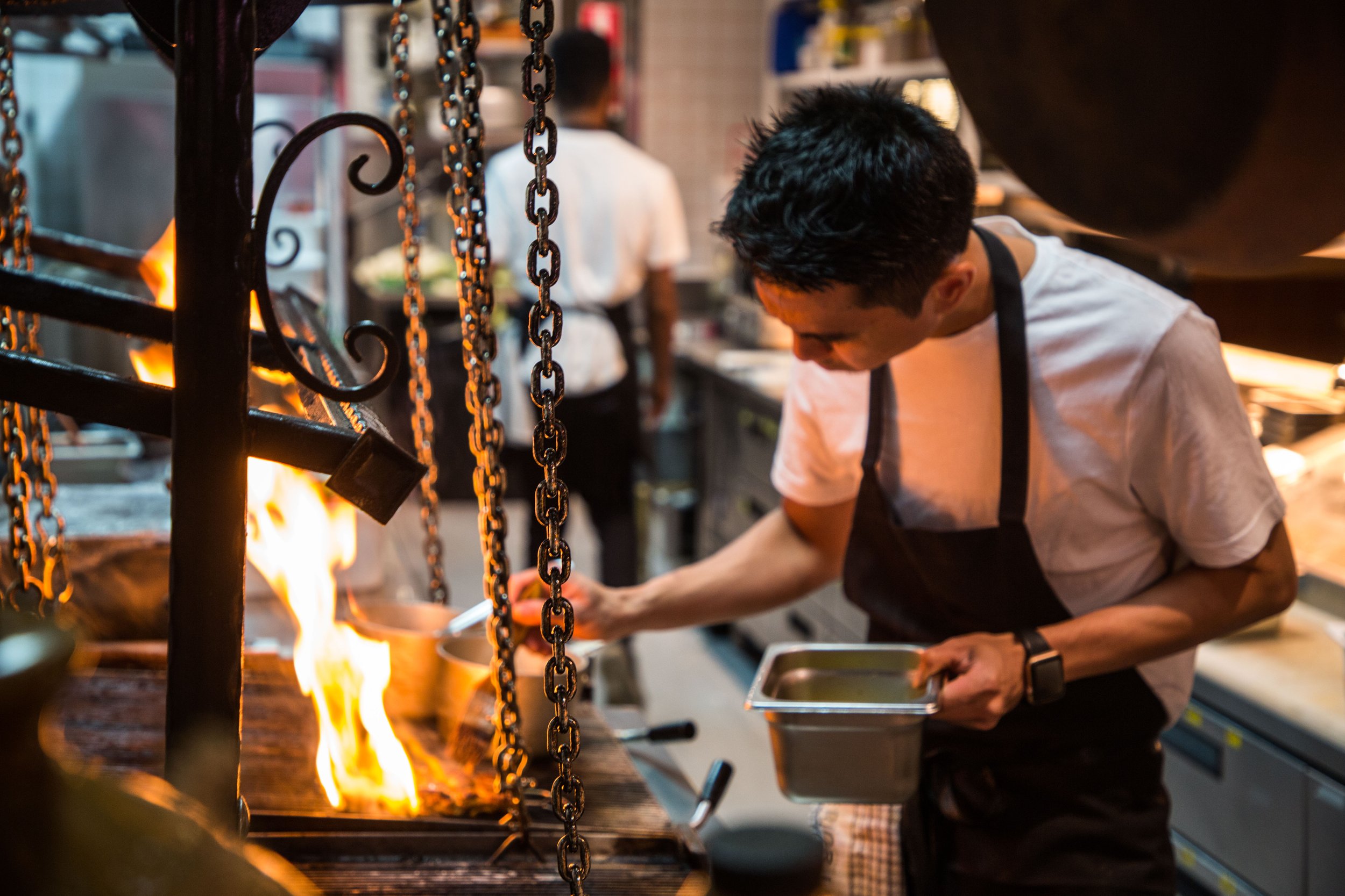  Chef preparing a dish on a chargrill with flames. Best restaurant in Lane Cove 
