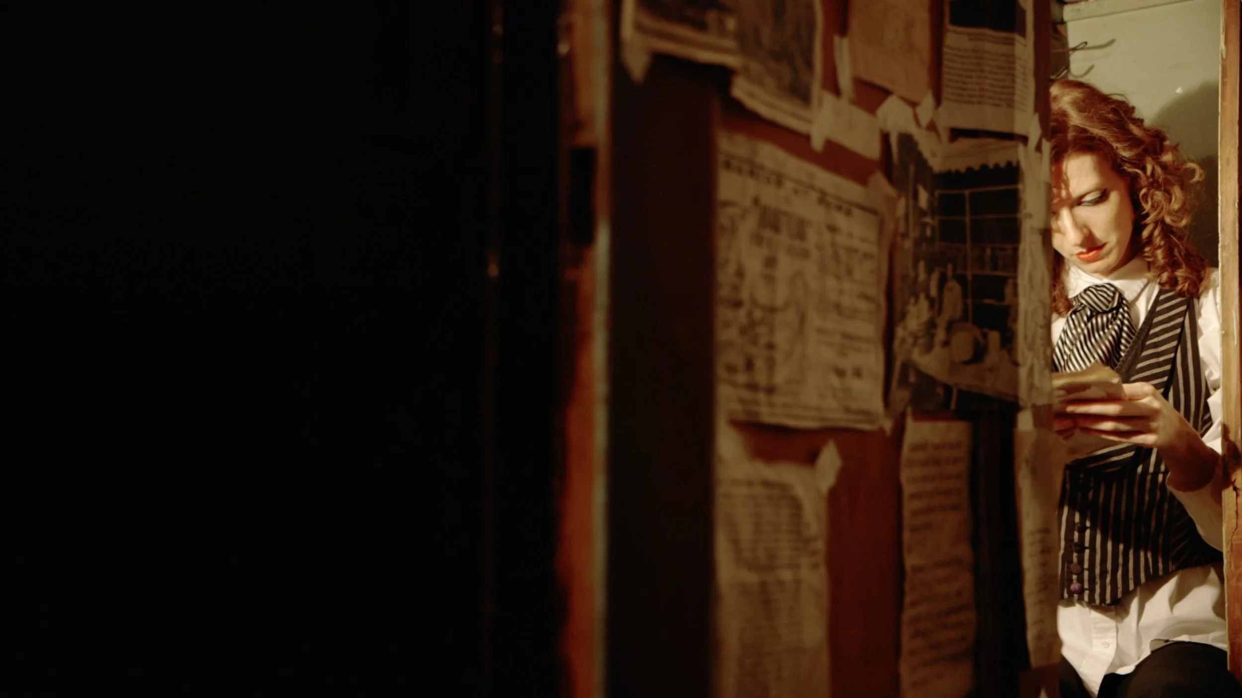 Poster for documentary titled 'Between Yourself and Me,' showing a woman reading a note in a closet, with a blurred background of a room with shelves and photos.