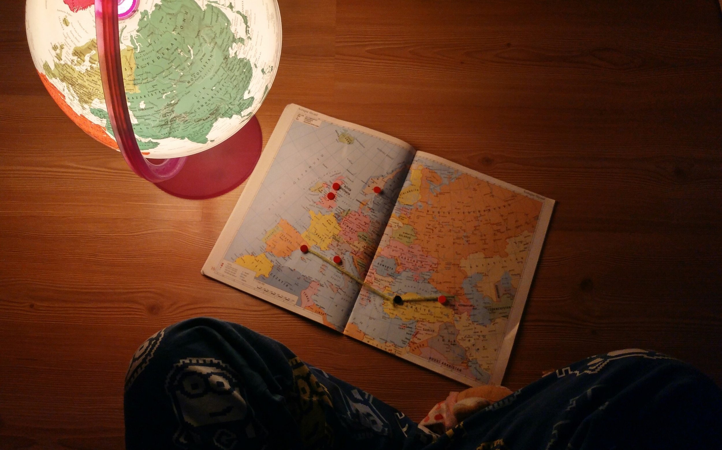 child looking at world map and globe