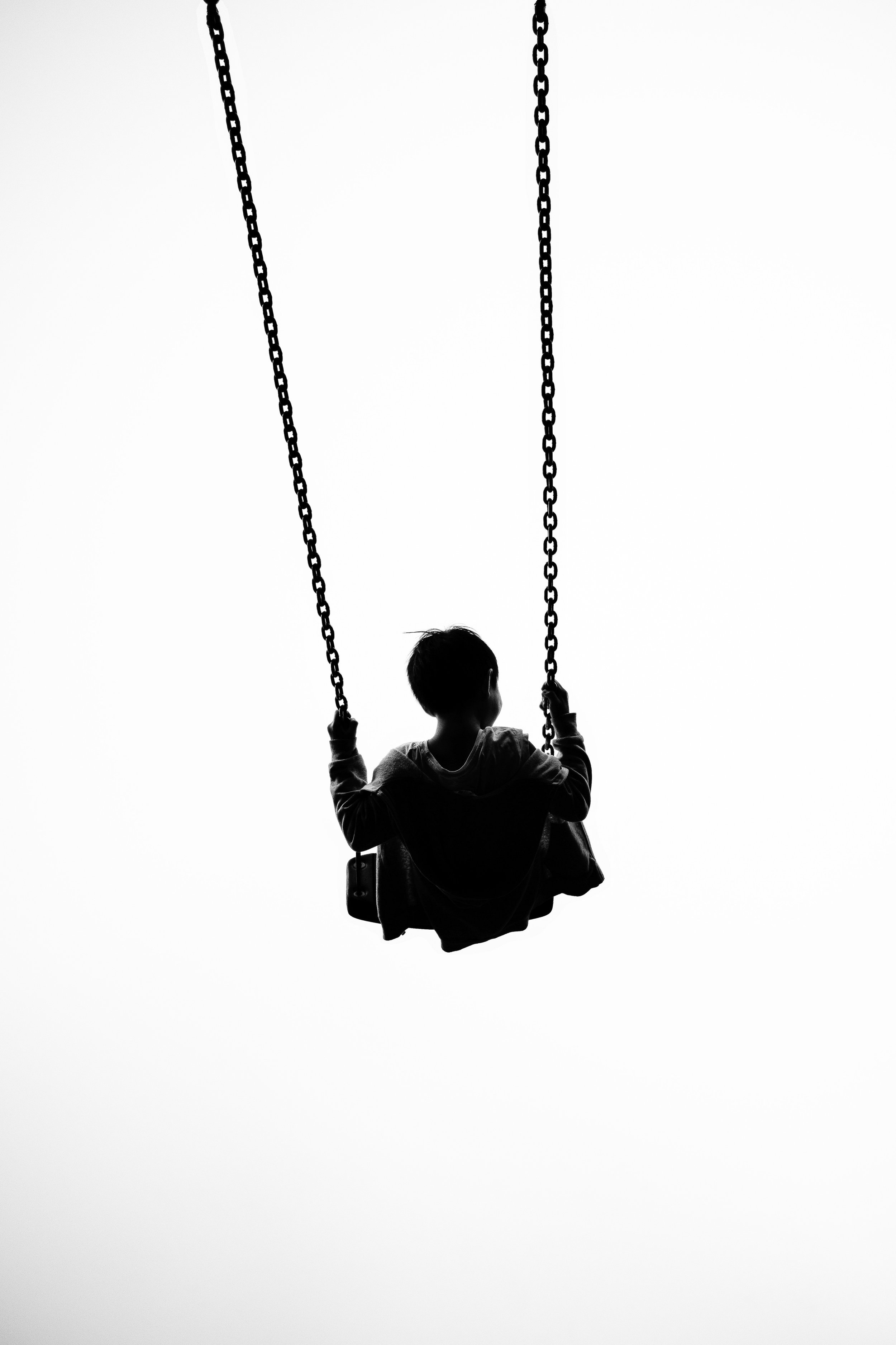 black-and-white photo of child on swing