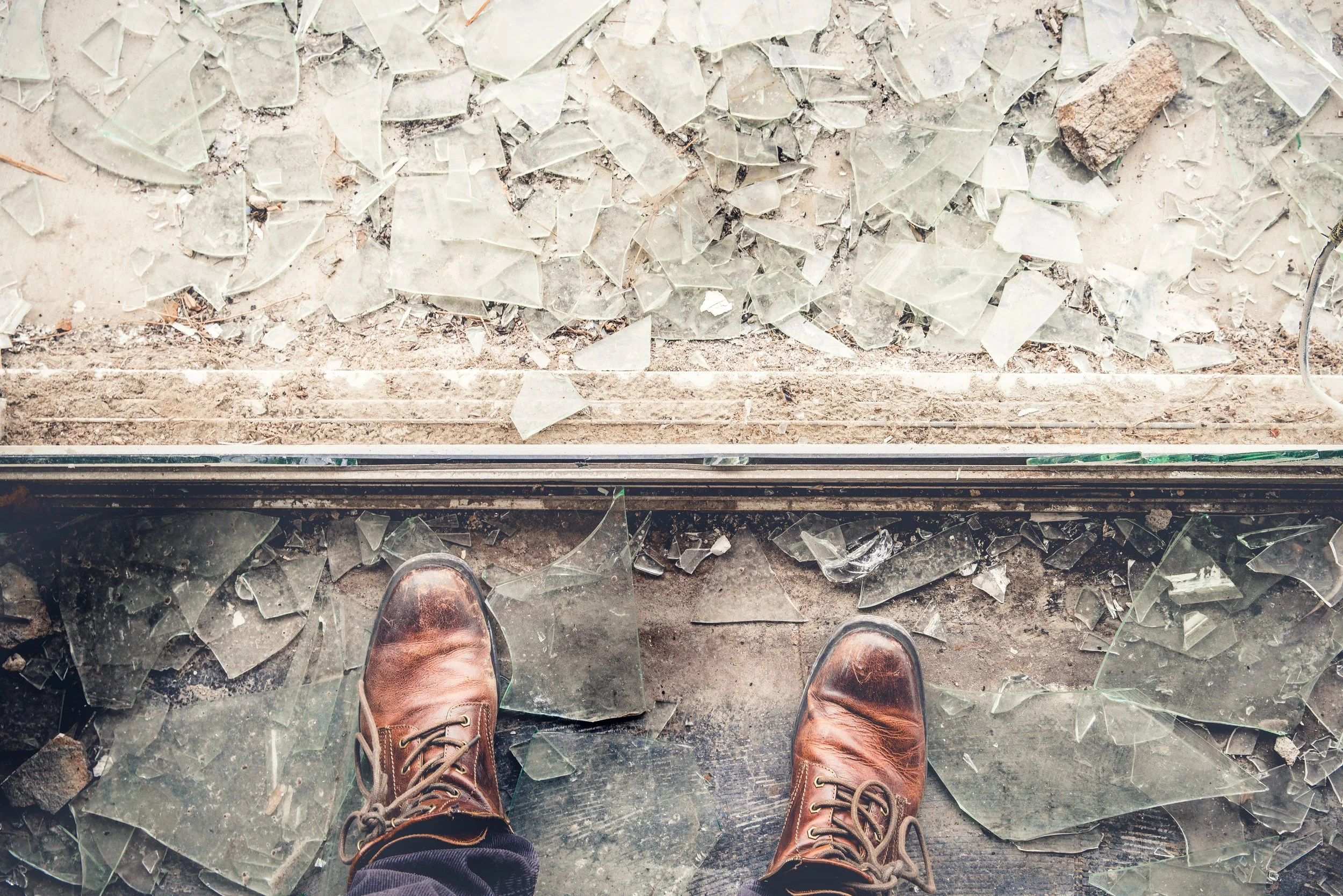 man with brown shoes standing on broken glass-signifying-mental-health-stigma