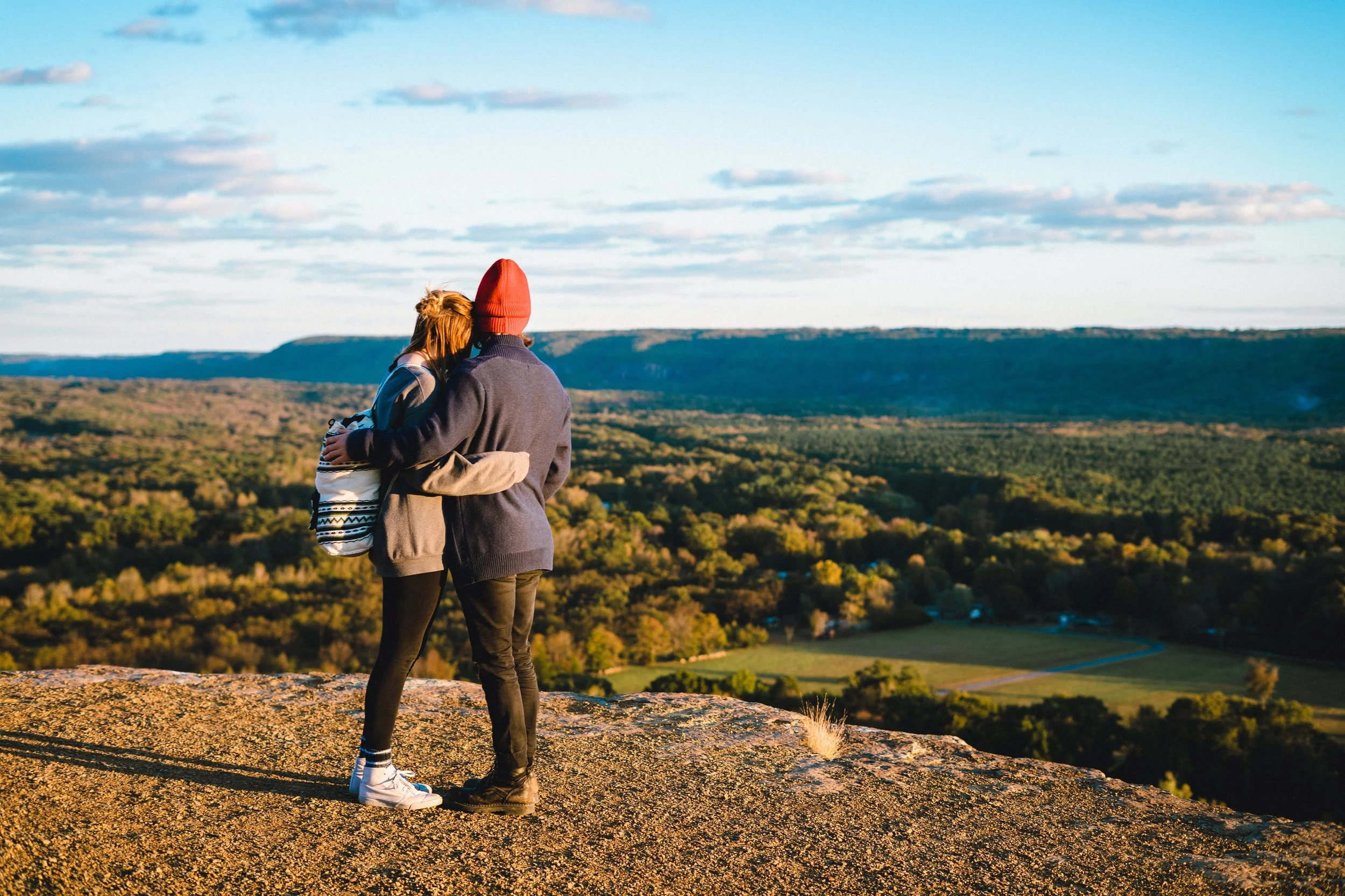 man and woman hugging while looking at beautiful landscape
