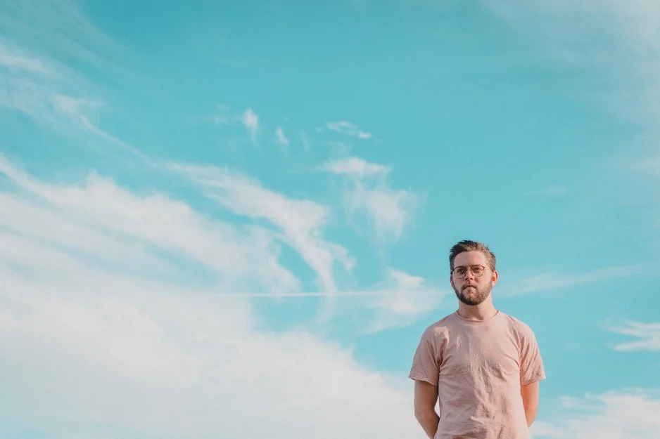 anxious thinking man standing with clouds in background