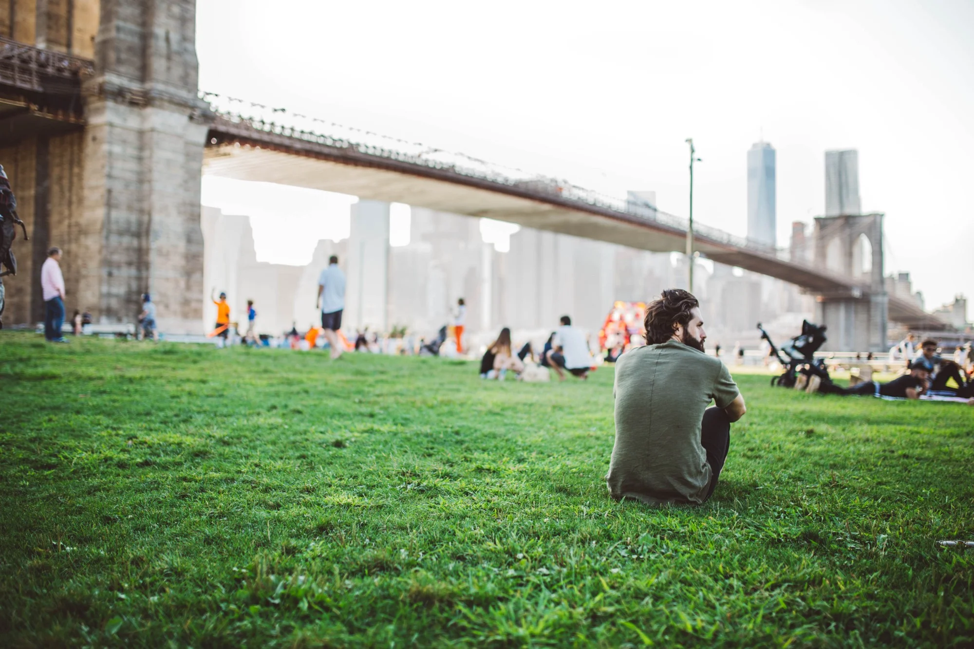 anxious bearded man sitting by himself in city park