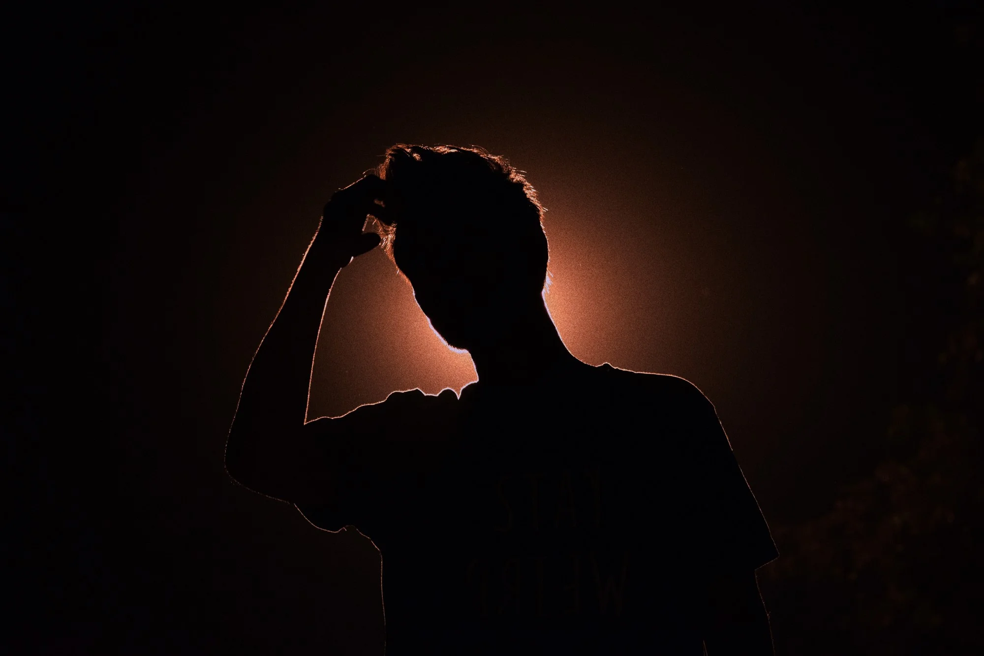 silhouette of anxious man scratching his head