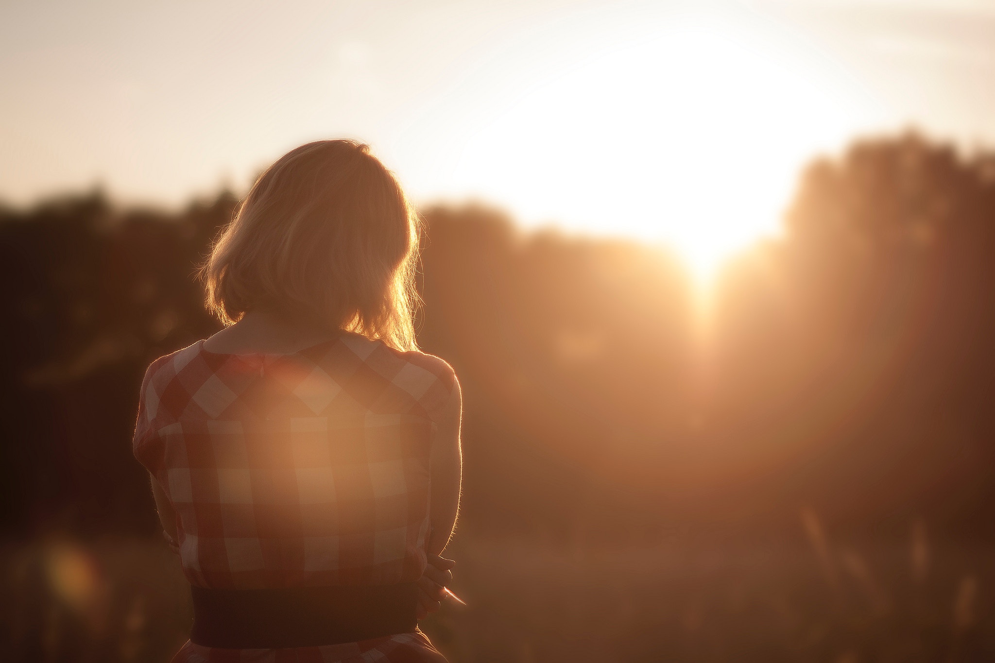 woman with mental illness looking at sunrise through trees