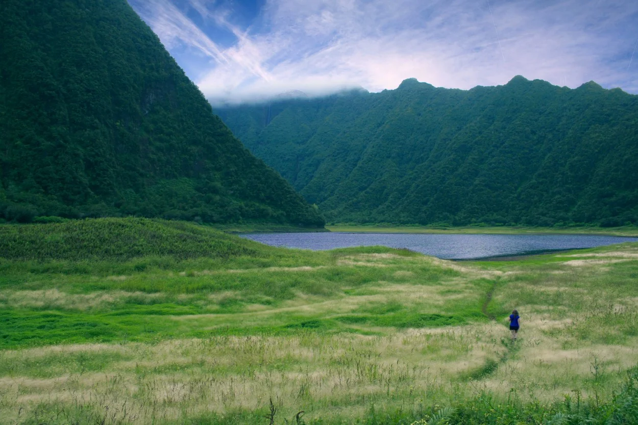 person walking in valley surrounded by mountains