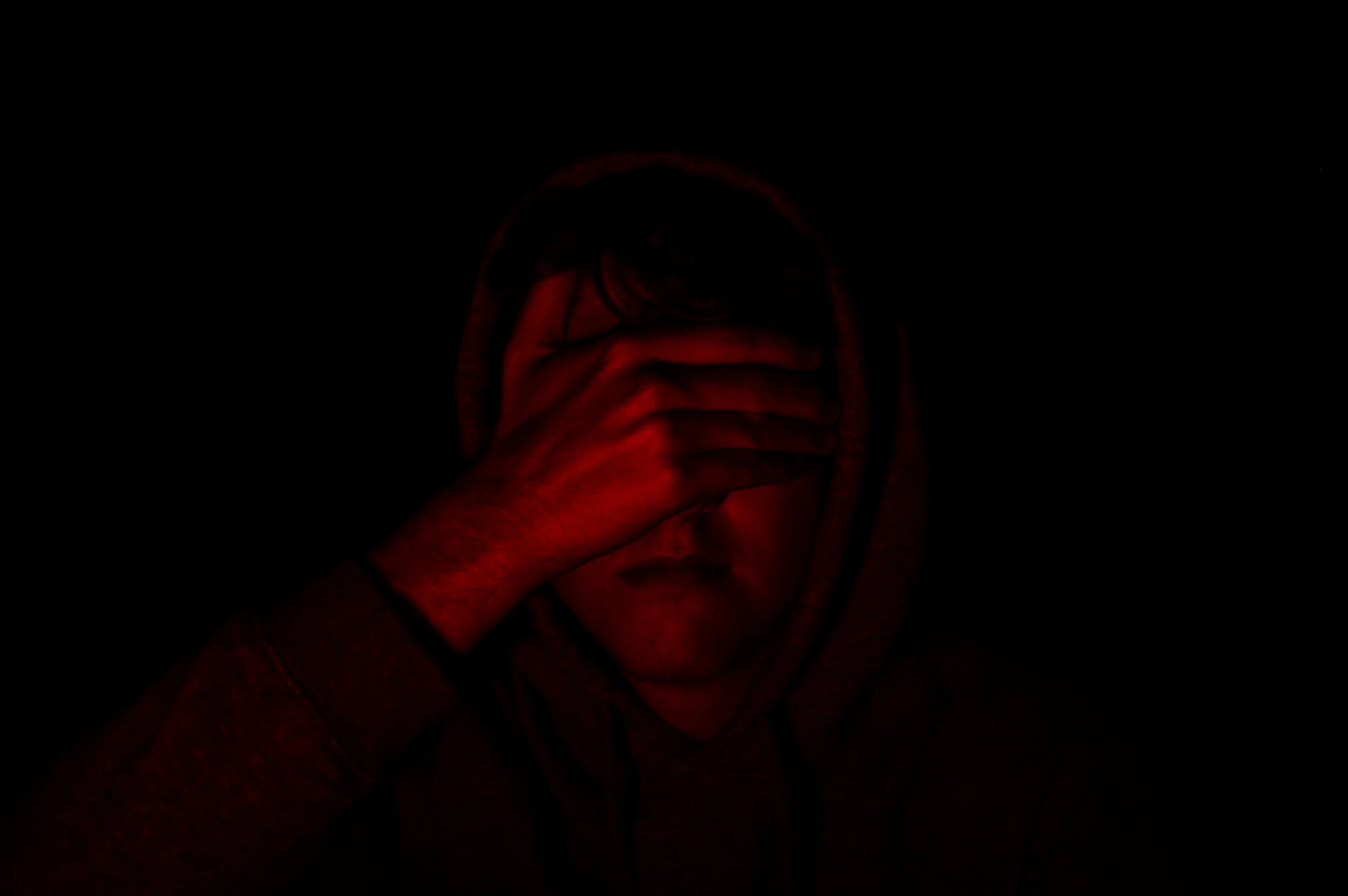 man hiding his face with his hand