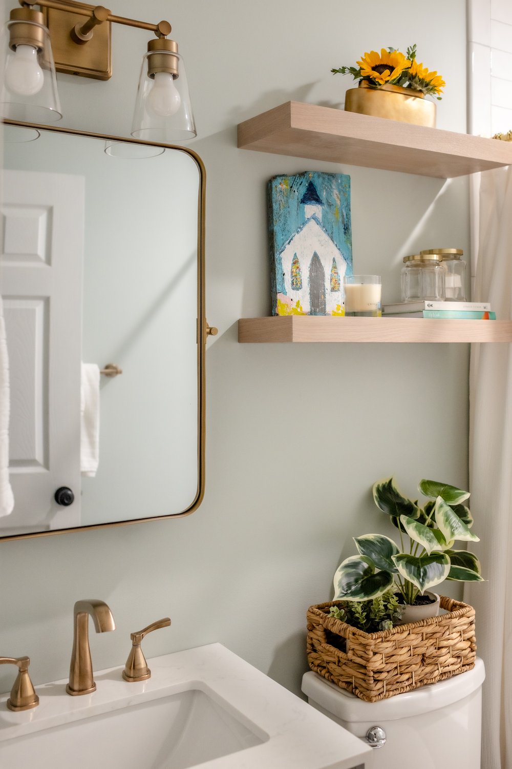  Guest bathroom with floating shelves and champagne bronze accessories 