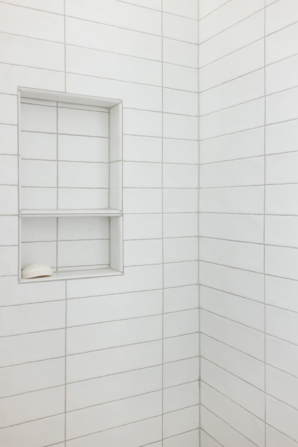  White, horizontally stacked shower tile with niche 