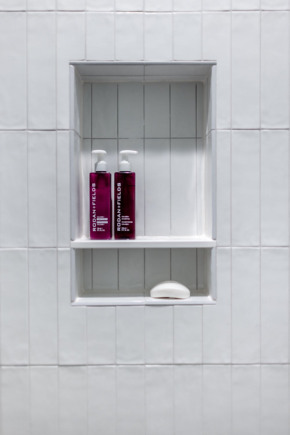  White shower tile in a vertical stack pattern with niche 