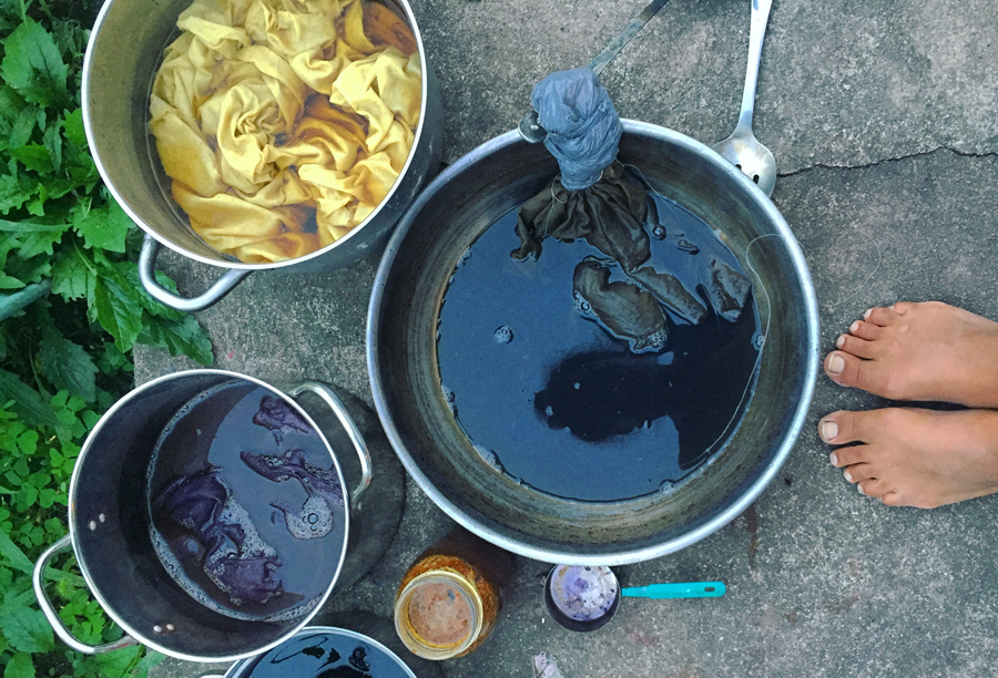 After removing fabric from yellow dyepot on the upper left, I rinsed the dye out, tied the pattern I desired, and wrapped the part I wanted to remain yellow in a plastic bag. Then this tied fabric went into a solution of a few tablespoons of iron liquor mixed with about a quart of water, center.