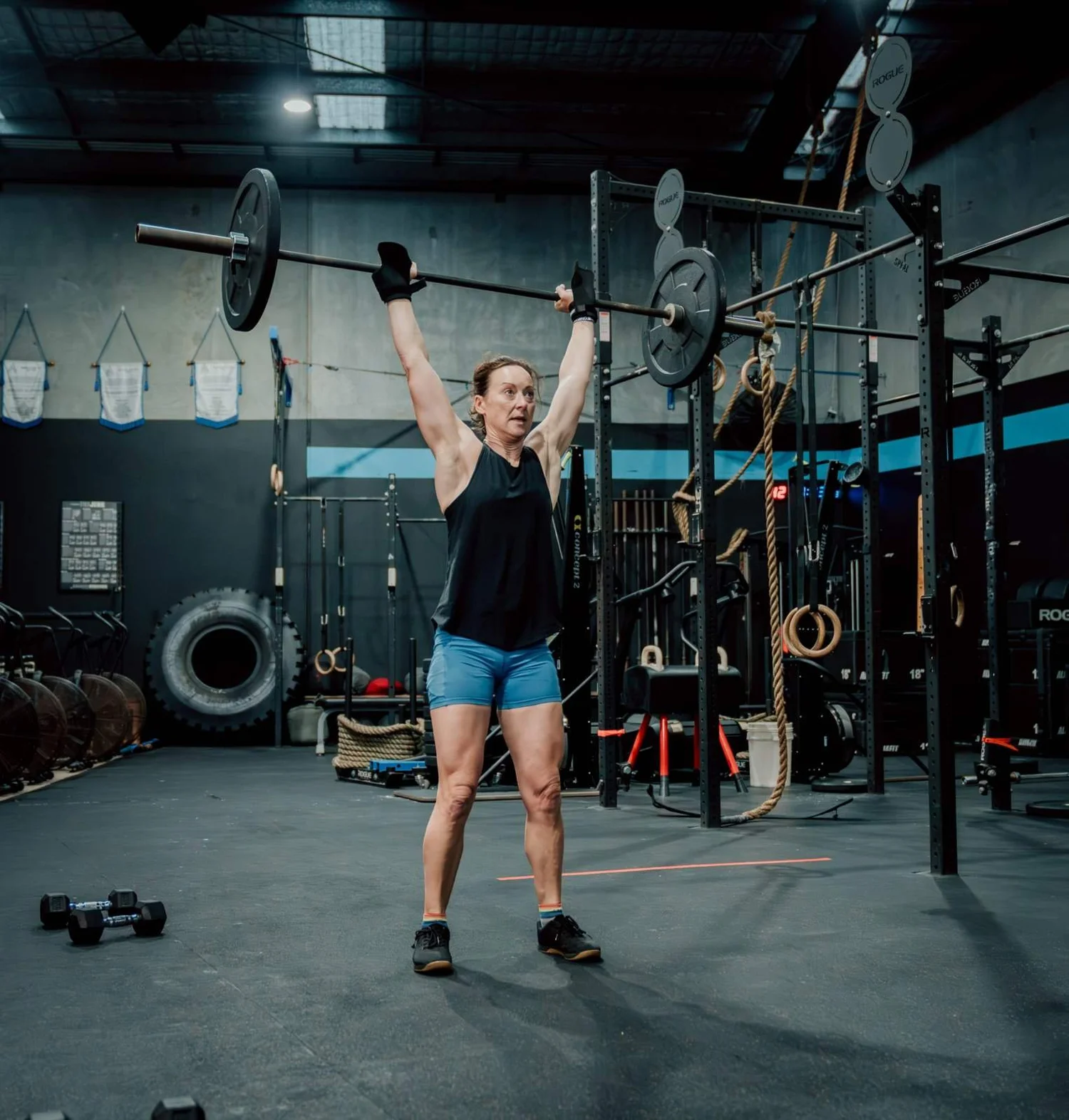 Member pressing a barbell overhead in a strength class at Accelerate Strength, Rozelle
