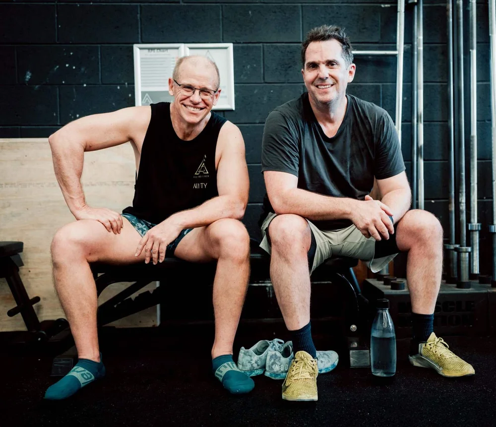Two Accelerate Strength members smiling on a bench after a strength class in Rozelle