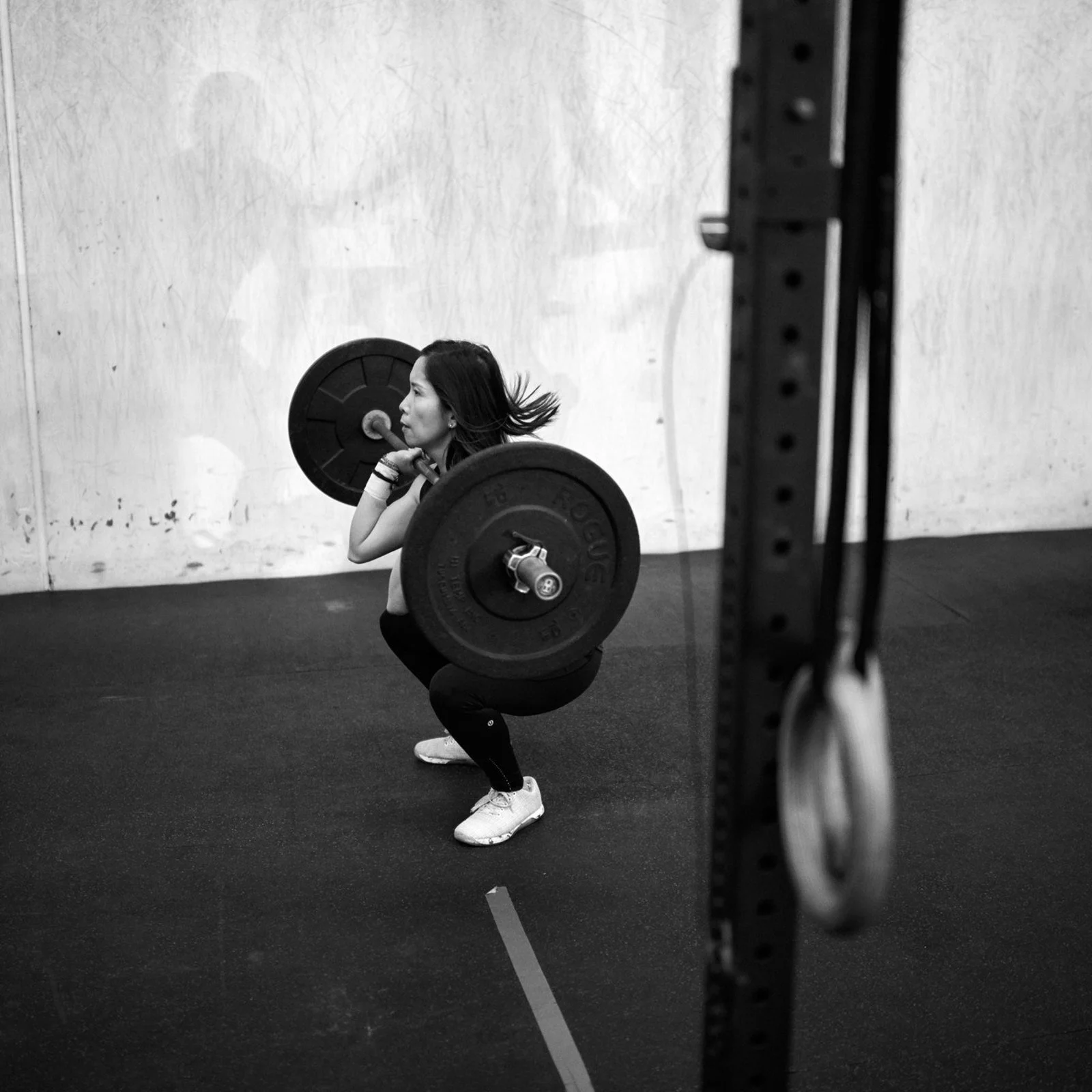 Member at the bottom of a front squat seen from the side with the whole foot on the floor