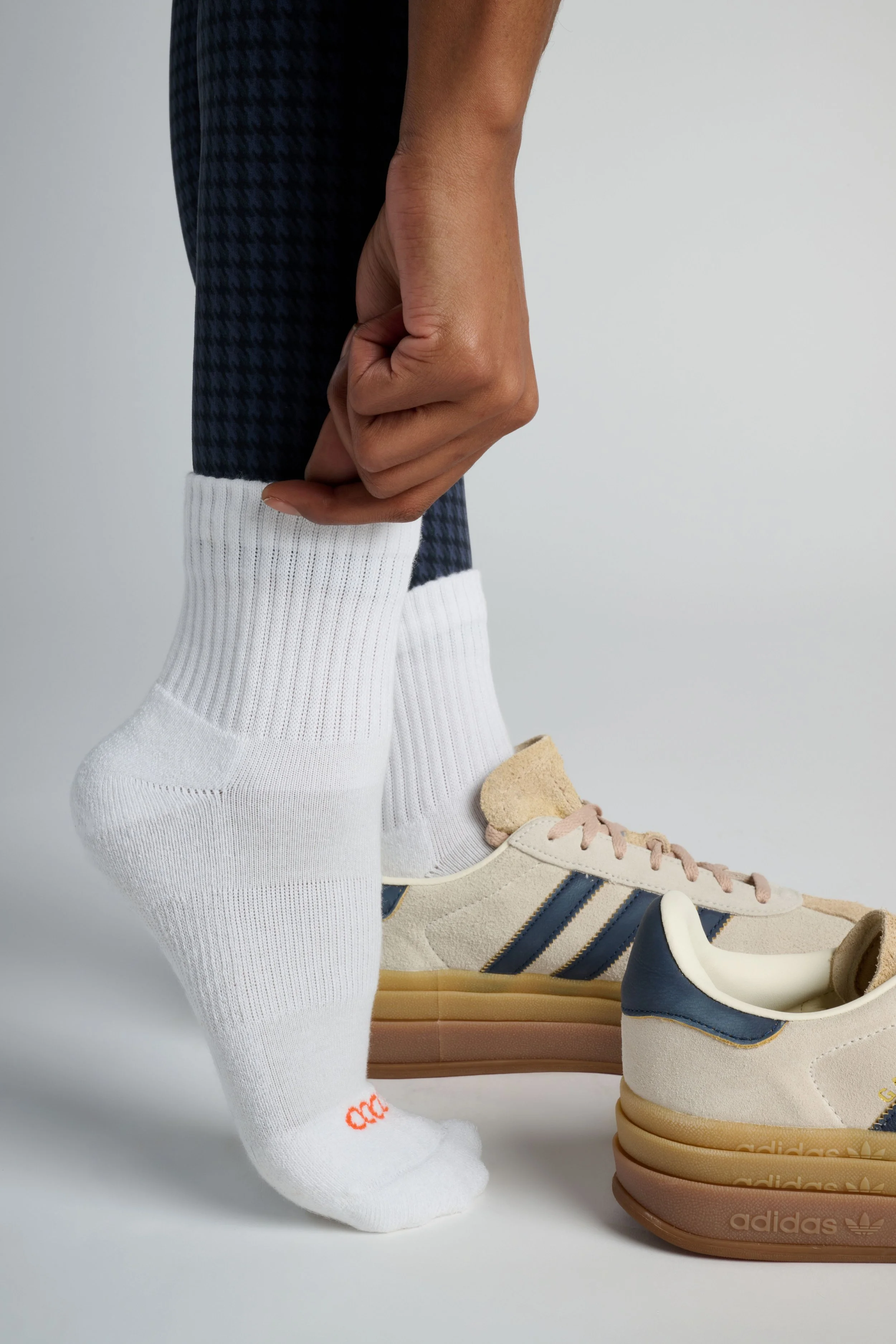 Women wearing white quarter-length performance running socks with cushioned support, moisture-wicking fabric for long runs and workouts.