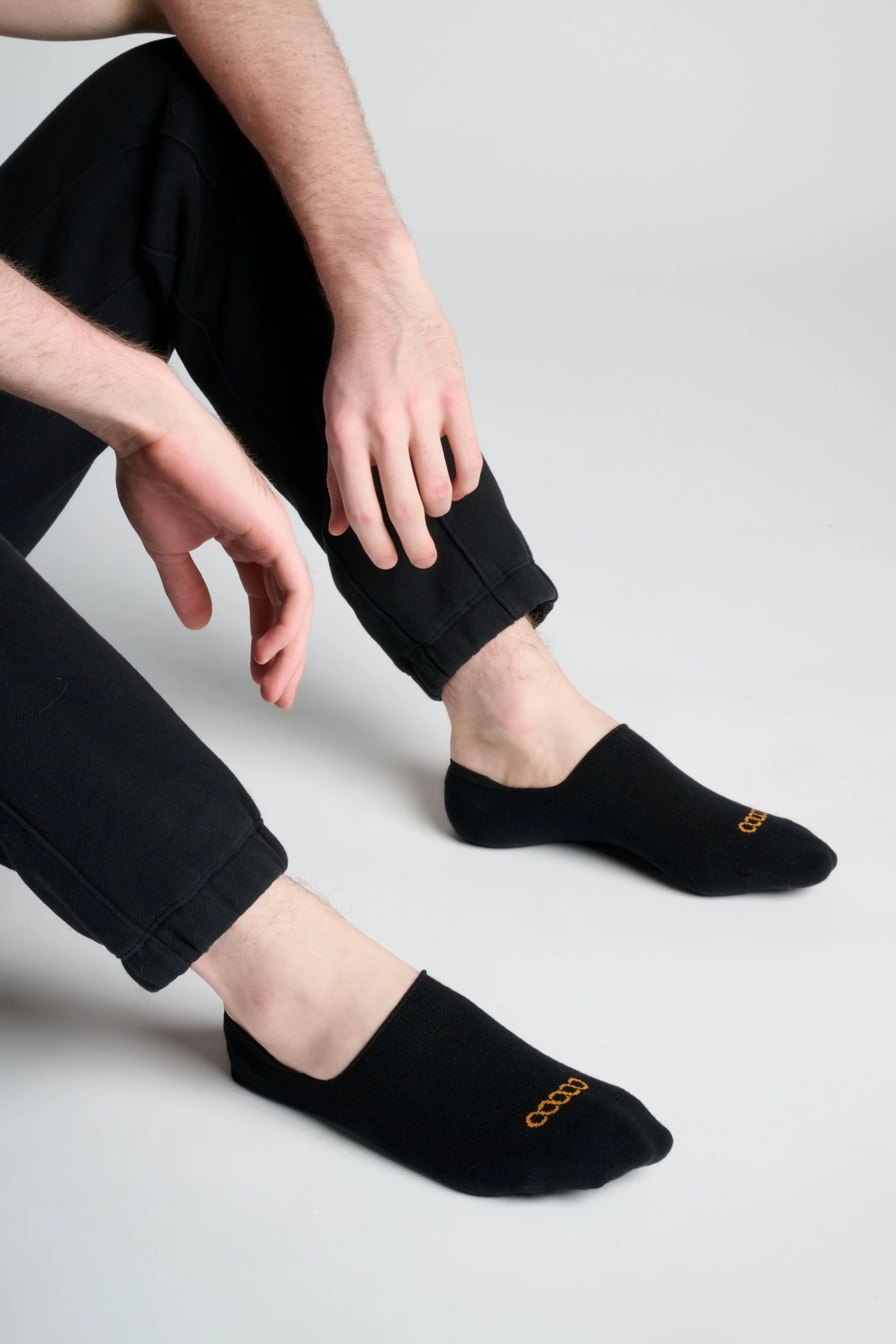 Man wearing black no-show performance running socks with athletic sneakers, low-profile fit designed for comfort and blister prevention.