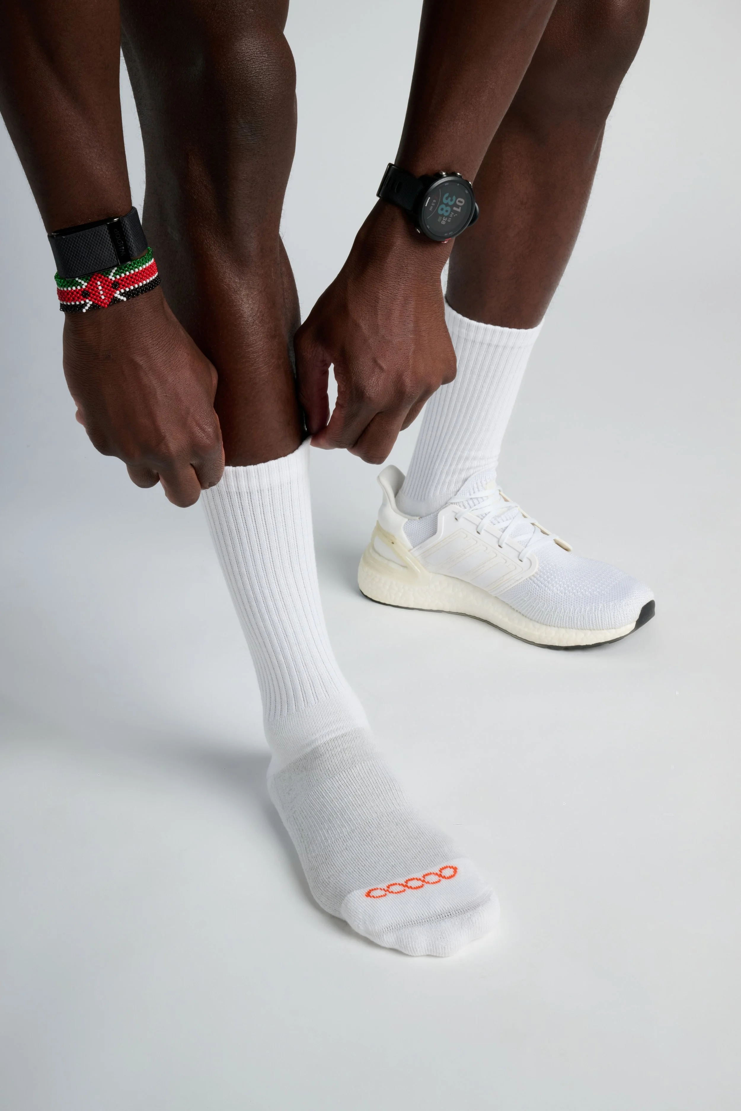 Man wearing black crew-length performance running socks with ribbed compression support and breathable stretch fit for endurance training.