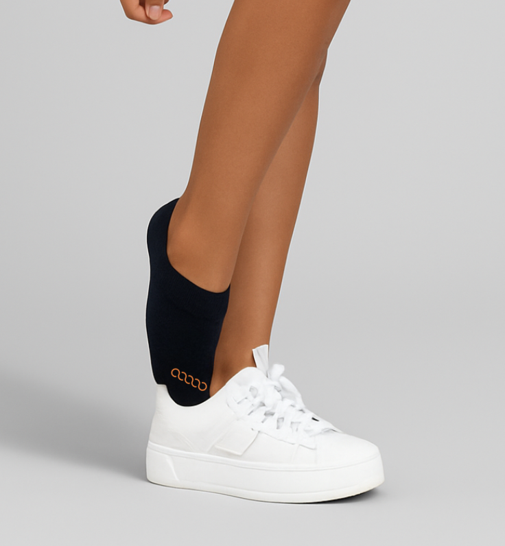 Women wearing black no-show performance running socks with white sneakers, low-profile fit designed for comfort and blister prevention.