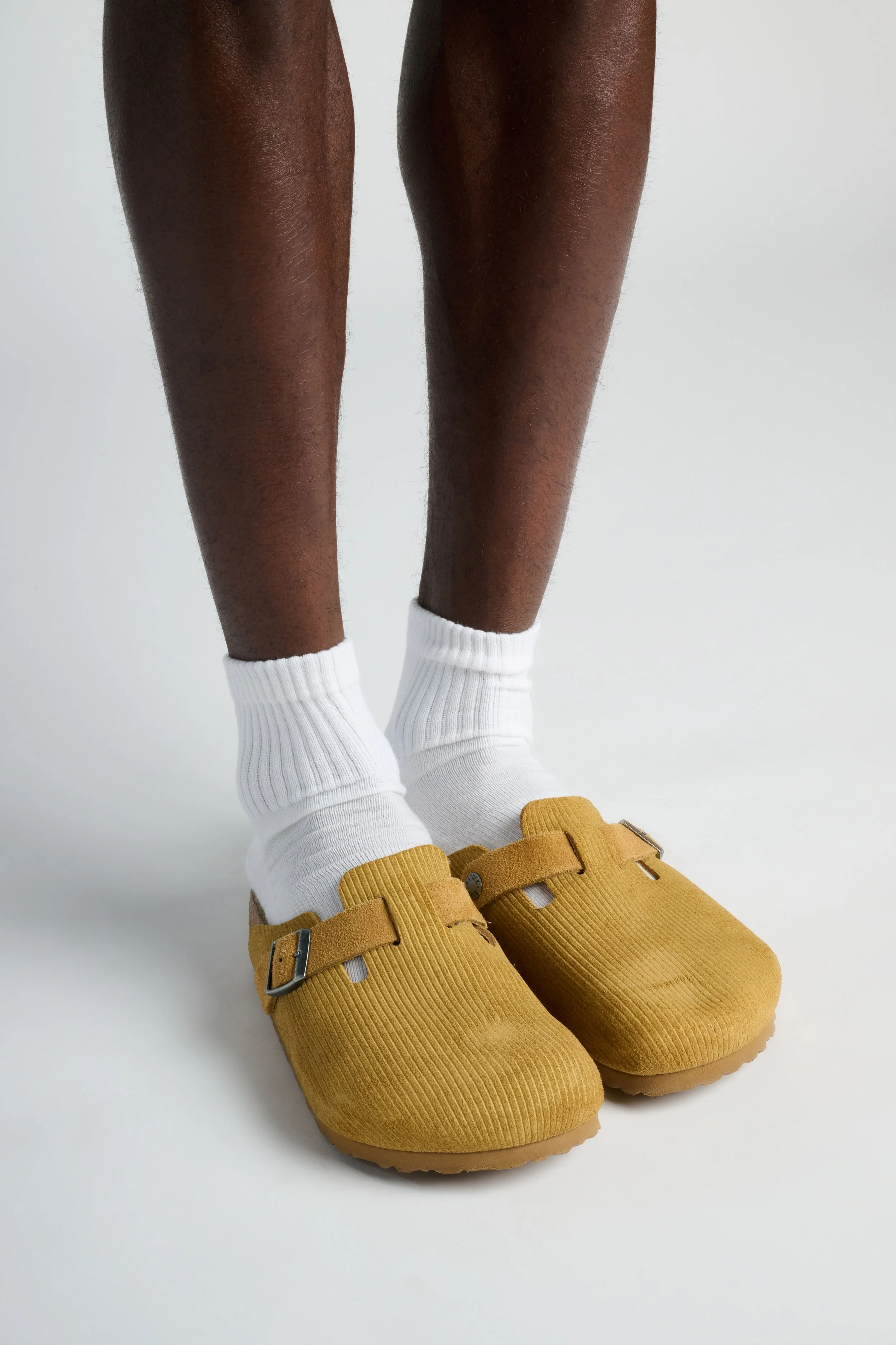 Man wearing white quarter-length performance running socks with cushioned sole and moisture-wicking fabric for long runs and workouts.