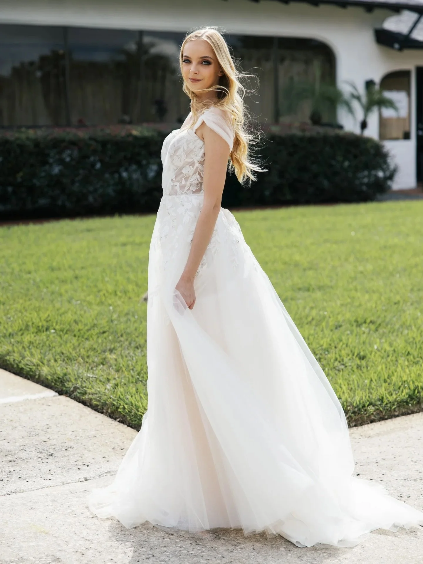 Soft, romantic, and effortlessly timeless.
This A-line beauty features a sweetheart neckline with leafy lace that flows naturally onto a lightweight tulle skirt, finished with airy cap sleeves for the most ethereal touch. Designed to move with you an