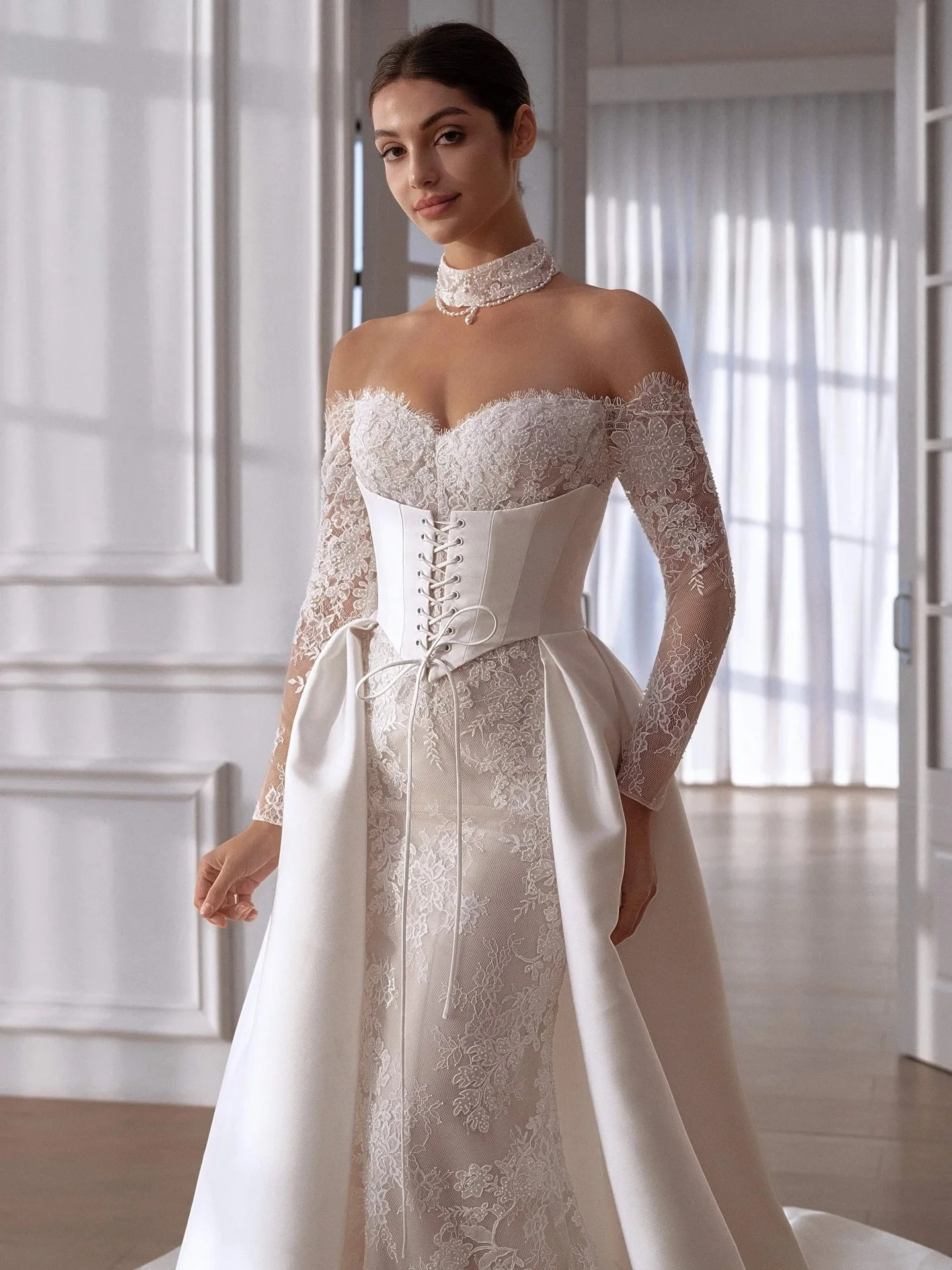 A lace-up Mikado overskirt cinches the waist and adds volume when you want it. Remove it for a sleek, contoured silhouette underneath. Two looks, one gown. Clean, versatile, and effortlessly elevated.

2-in-1 wedding dress, mermaid gown, overskirt br