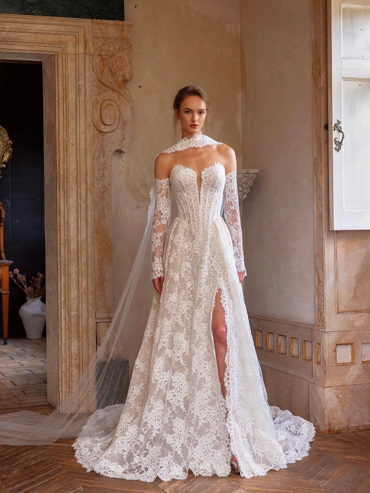 Romantic lace with just the right amount of drama 🤍 
A plunging corset bodice, off-the-shoulder lace sleeves, and a statement slit make this A-line wedding gown unforgettable from every angle.