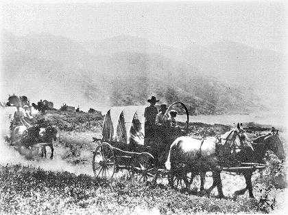 Made July 2, 1897 near mouth of Emigration Canyon, Salt Lake City, Utah. Used by permission, Utah State Historical Society, all rights reserved - Photograph: Salt Lake Tribune. Just as one would do so 100 years later, in 1897 for the 50-year Silver Jubilee Celebration of the Mormon Trail, a re-enactment wagon train enters the Salt Lake Valley. This view is looking generally south from the bench north of Emigration Canyon.