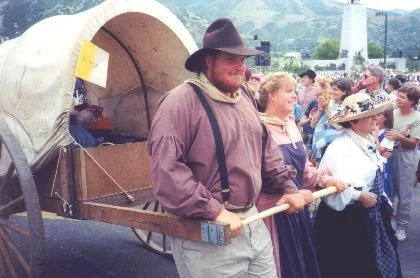 Made July 24, 1997 at This is the Place State Park, Salt Lake City, Utah. Handcart - The Last Few Feet. Photograph by Steve Berlin. This happy man has come through all the way from Winter Quarters, Nebraska, more than 1,000 miles. With the This Is The Place Monument over his shoulder he has heard the last of the speeches, songs and tributes, but not yet the final cheers and accolades of the vast and admiring crowd as he pulls his cart the final few feet to the last camp.