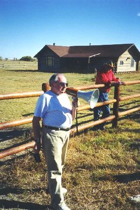 5. Made 10/18/97 , ~22 miles North of Wendover, UT at Donner Spring. George Ivory at Donner Springs. Photograph by Steve Berlin. Utah Crossroads Chapter President, George Ivory, standing inside the fence erected by the chapter to protect the site, describes Donner Spring, its history and current status to the group. The spring is located on the Stephens Ranch and is open to the public. The chapter has provided printed literature at the here in addition to the interpretive signage.