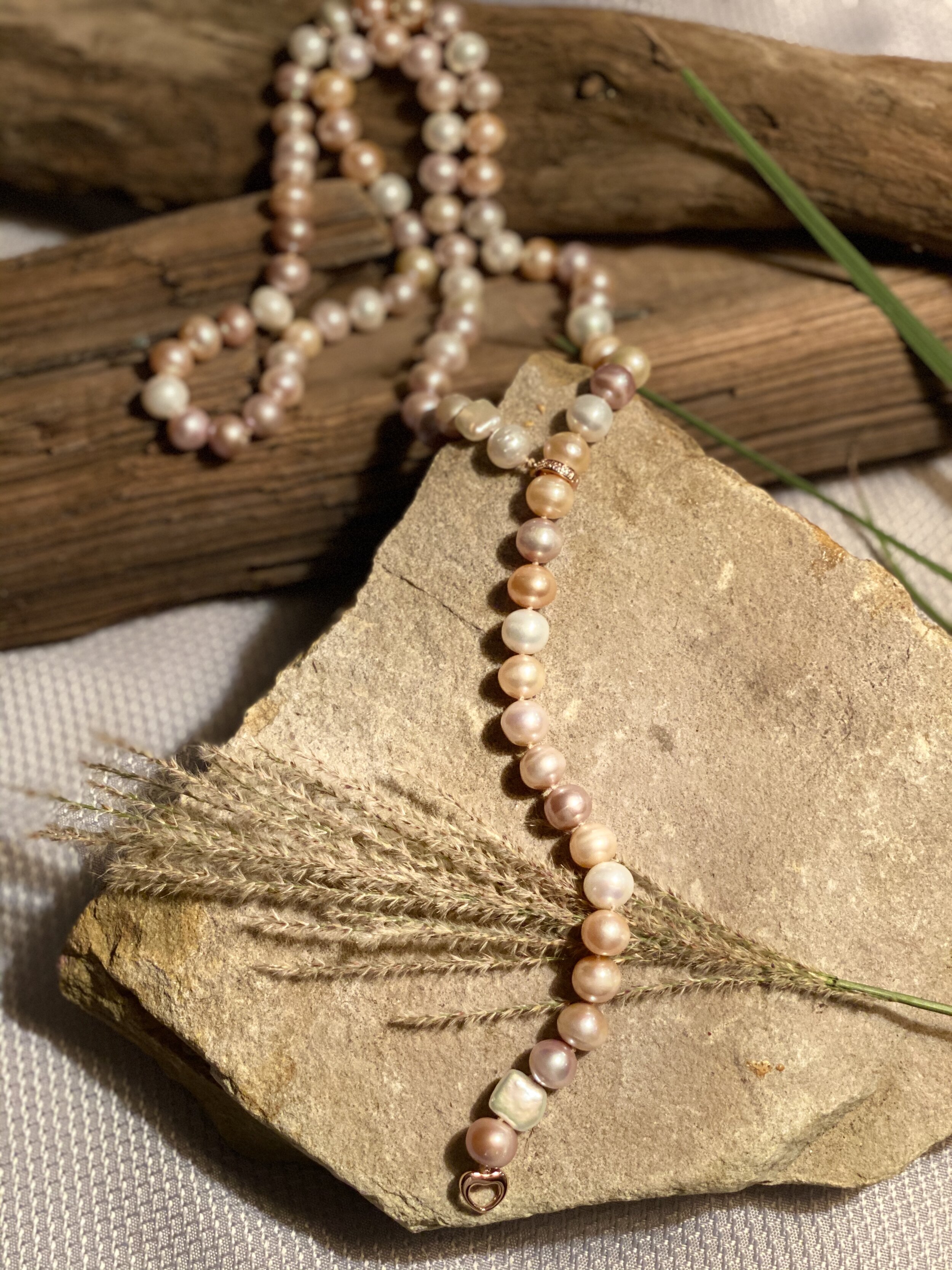 36” Natural freshwater pearls in shades of peach to white.