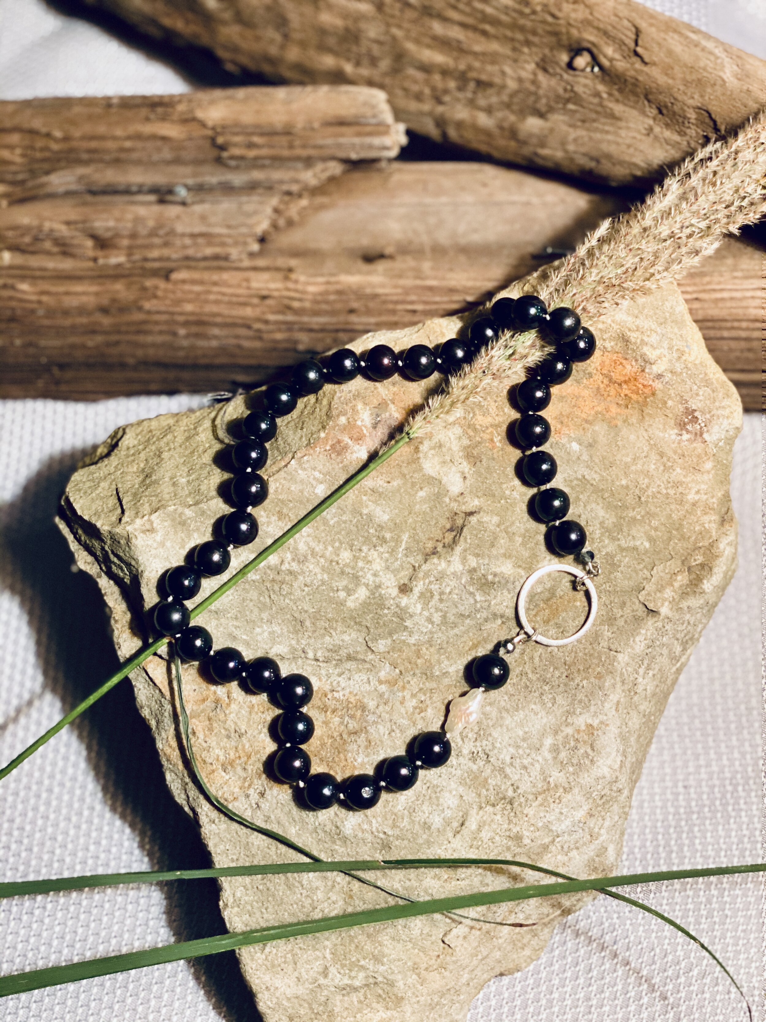 18” Iridescent black freshwater pearls with natural cross accent pearl