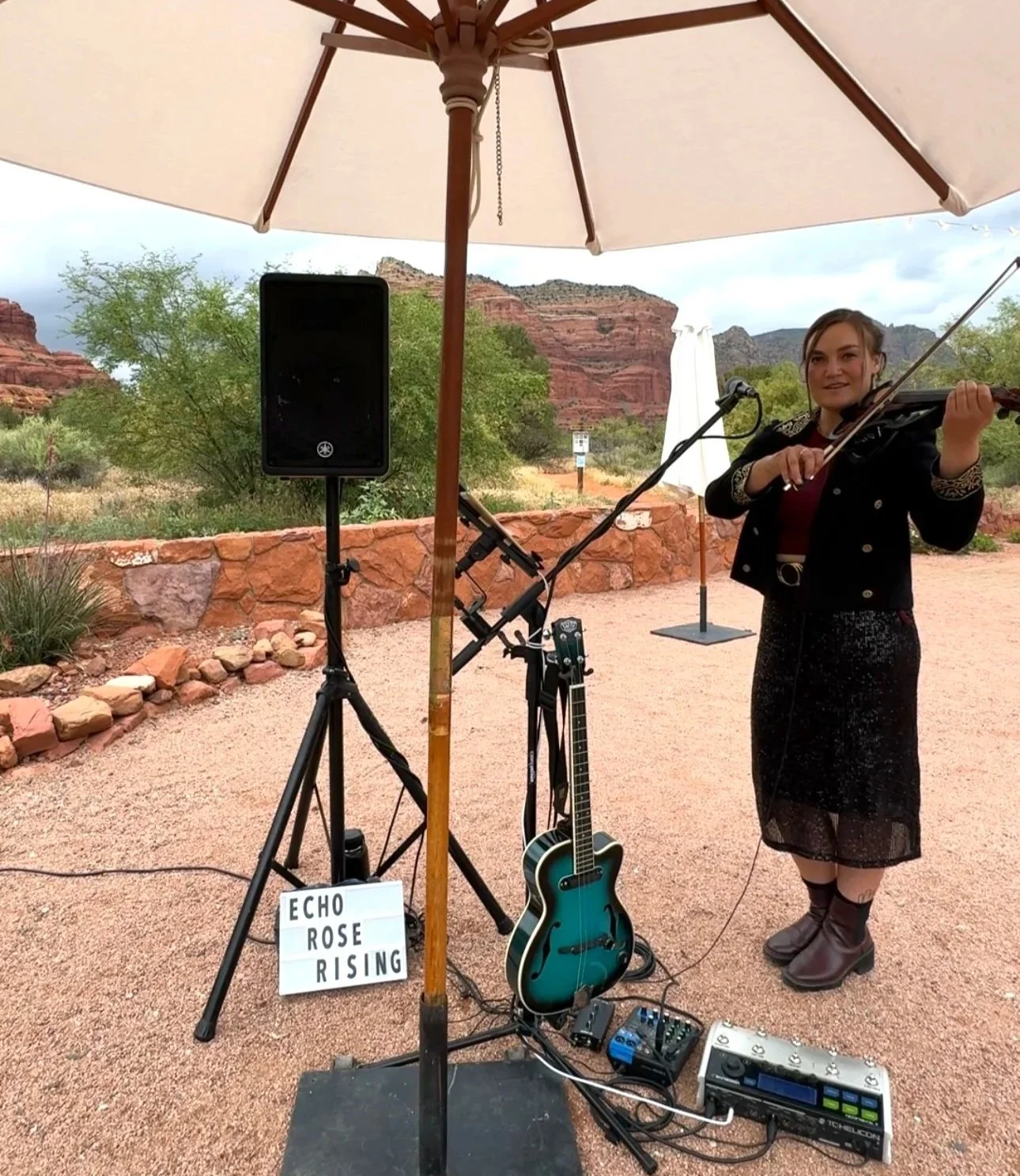Violinist posing at wedding locations in Sedona Arizona, prepared to play a custom song as the bride enters the aisle against a stunning red rock desert backdrop