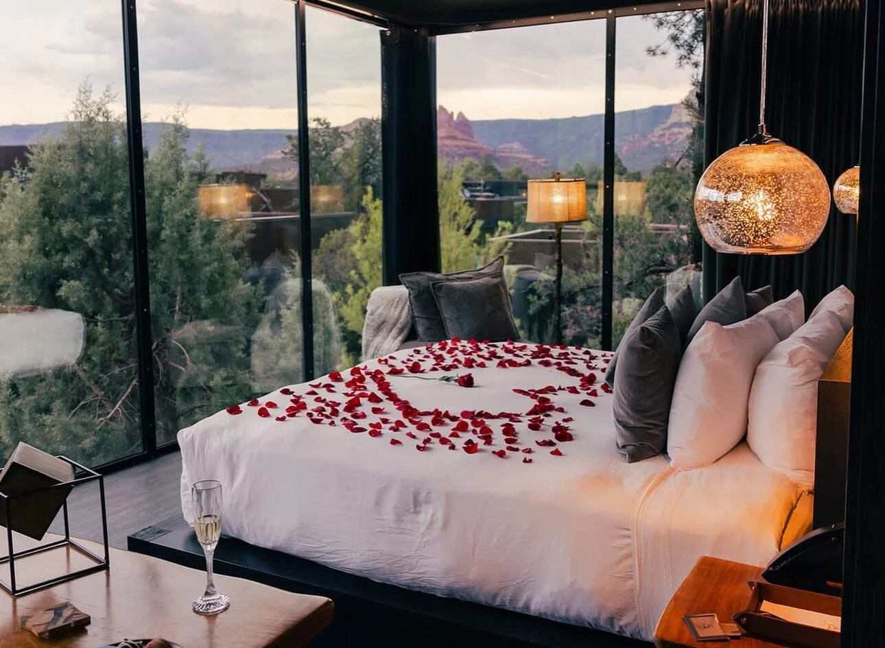 Luxury suite for a Sedona romantic getaway with rose petals on the bed and a stunning view of the Sedona red rocks