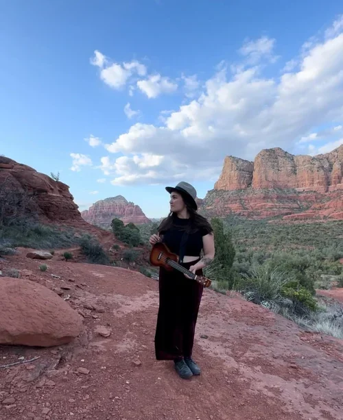 Musician holding a ukulele in Sedona’s desert scenery, inspiring unique elopement ideas